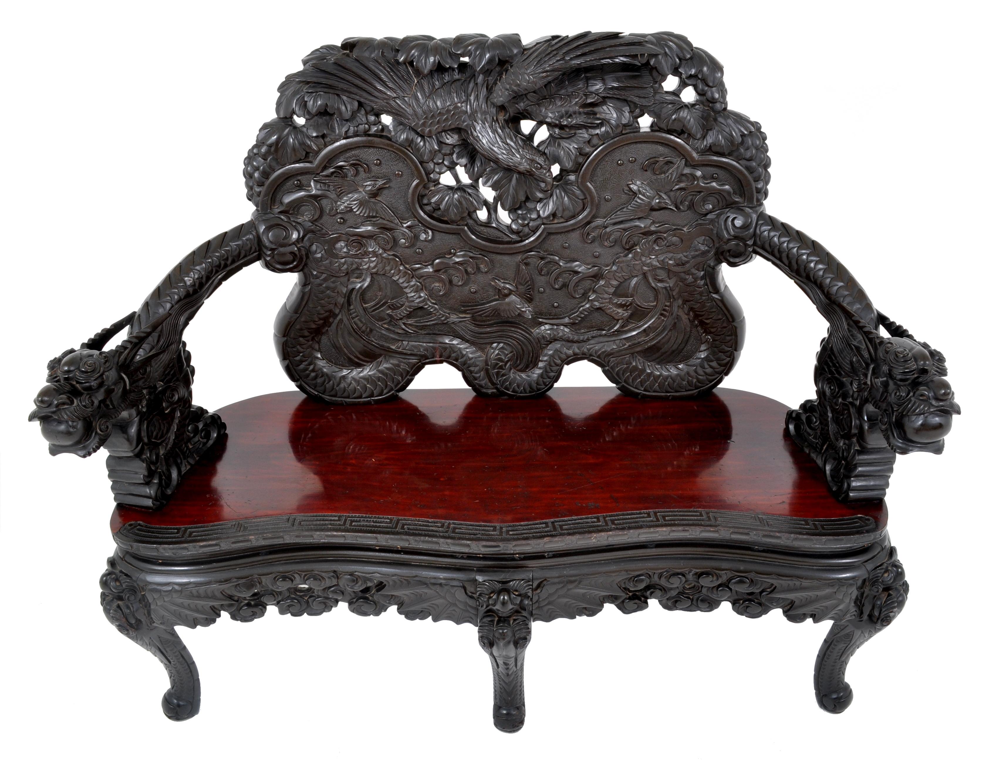 Antique Chinese Qing Dynasty carved rosewood dragon loveseat/sofa/bench, circa1890. This sofa is made for the Chinese market in Japan in the late 19th century. The bench is finely and lavishly carved with a pair of entwined dragons, each with a