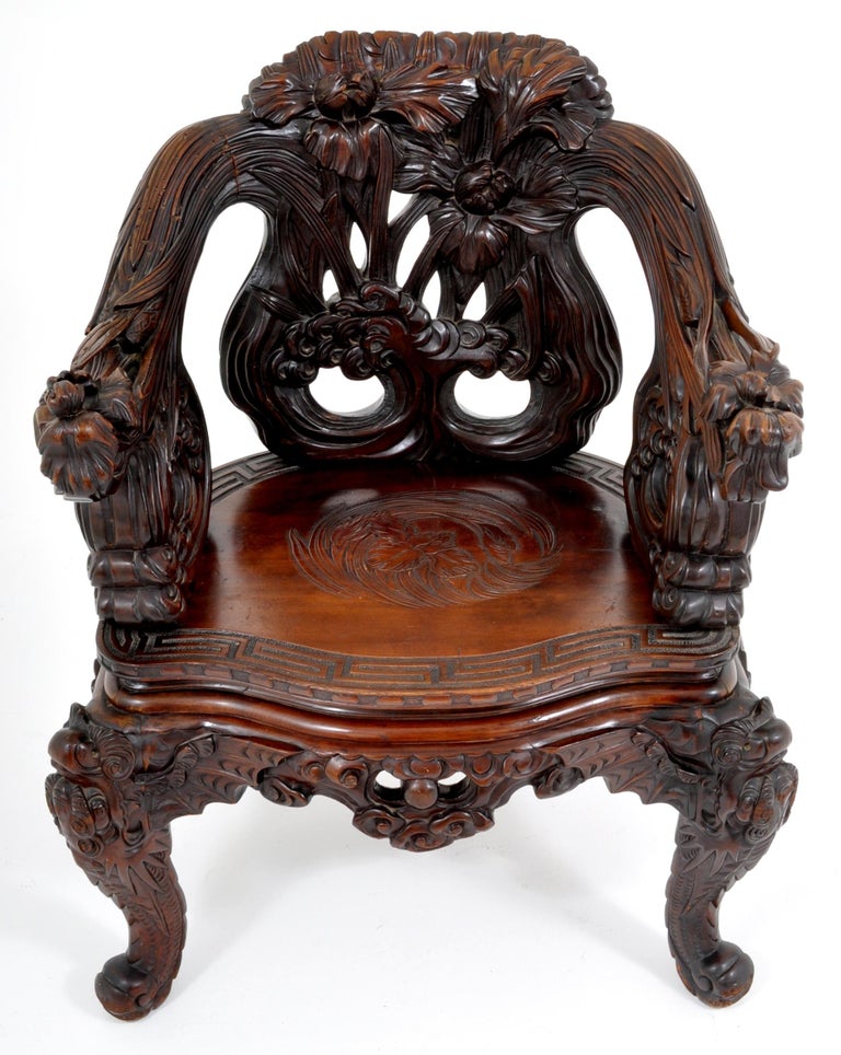 Antique Chinese Qing dynasty carved rosewood throne chair, circa 1890. The chair made for the Chinese market in Japan in the late 19th century. The chair finely and lavishly carved in an organic form with prunus leaves and flowers, the seat also