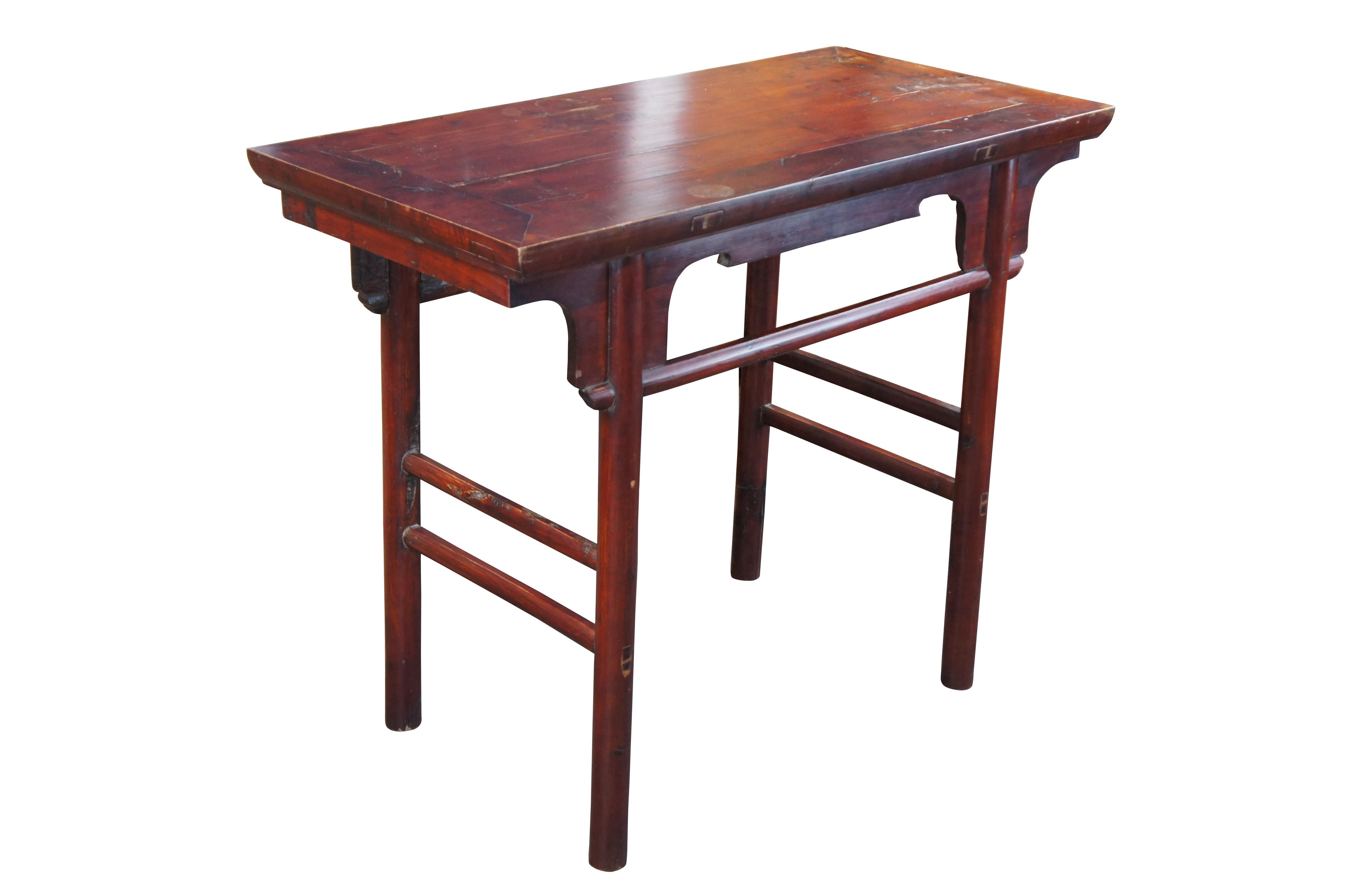 An antique 19th Century Chinese Qing Dynasty (Ming Style) Altar Table. Made from elm with traditional mortise and tenon construction. Features a shapely apron and contoured spandrels over long legs connected by stretchers from front to back. Finish