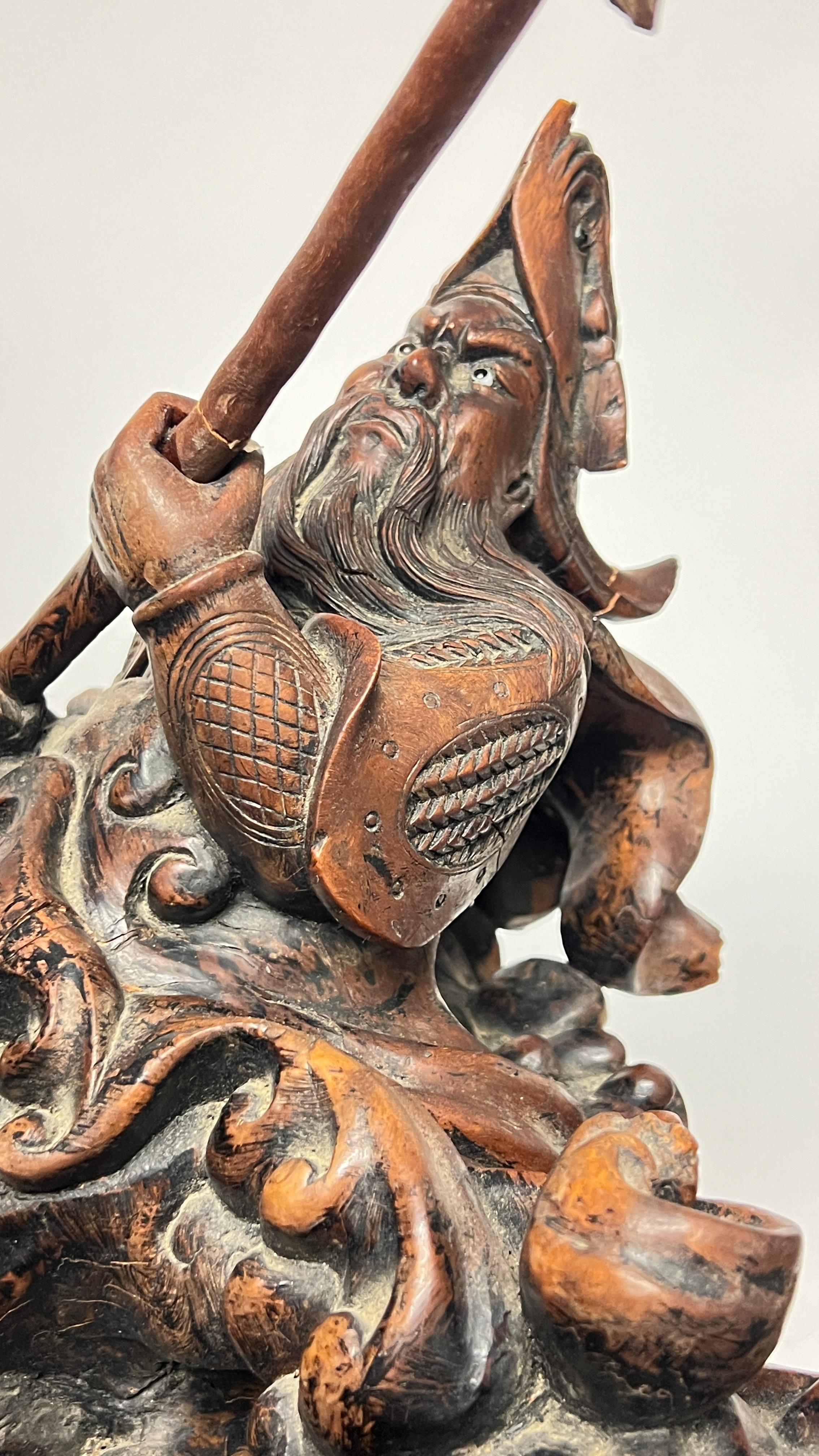Our monumental carved wooden sculpture, 50 inches tall, depicts a mythological female figure rising above rolling seas, surrounded by various sea creatures including crustaceans, fish and turtles, and figures of two menacing figures wielding spears,
