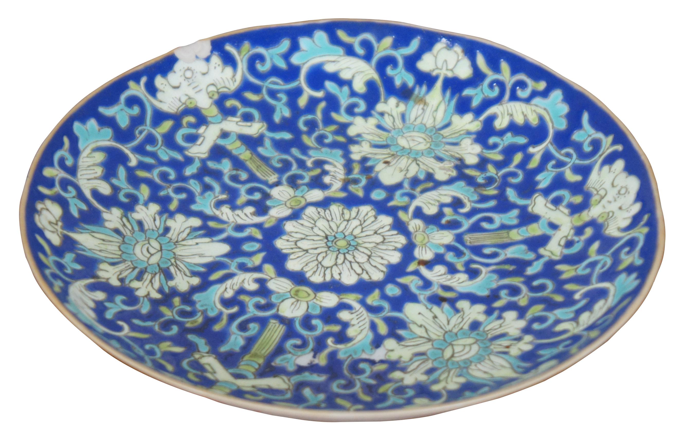 Antique Qing Dynasty porcelain cloisonne enameled lotus scroll plate, dish or shallow bowl featuring a field of blue with white lotus flowers, green bamboo, and orange bats under the edge. Measure: 7