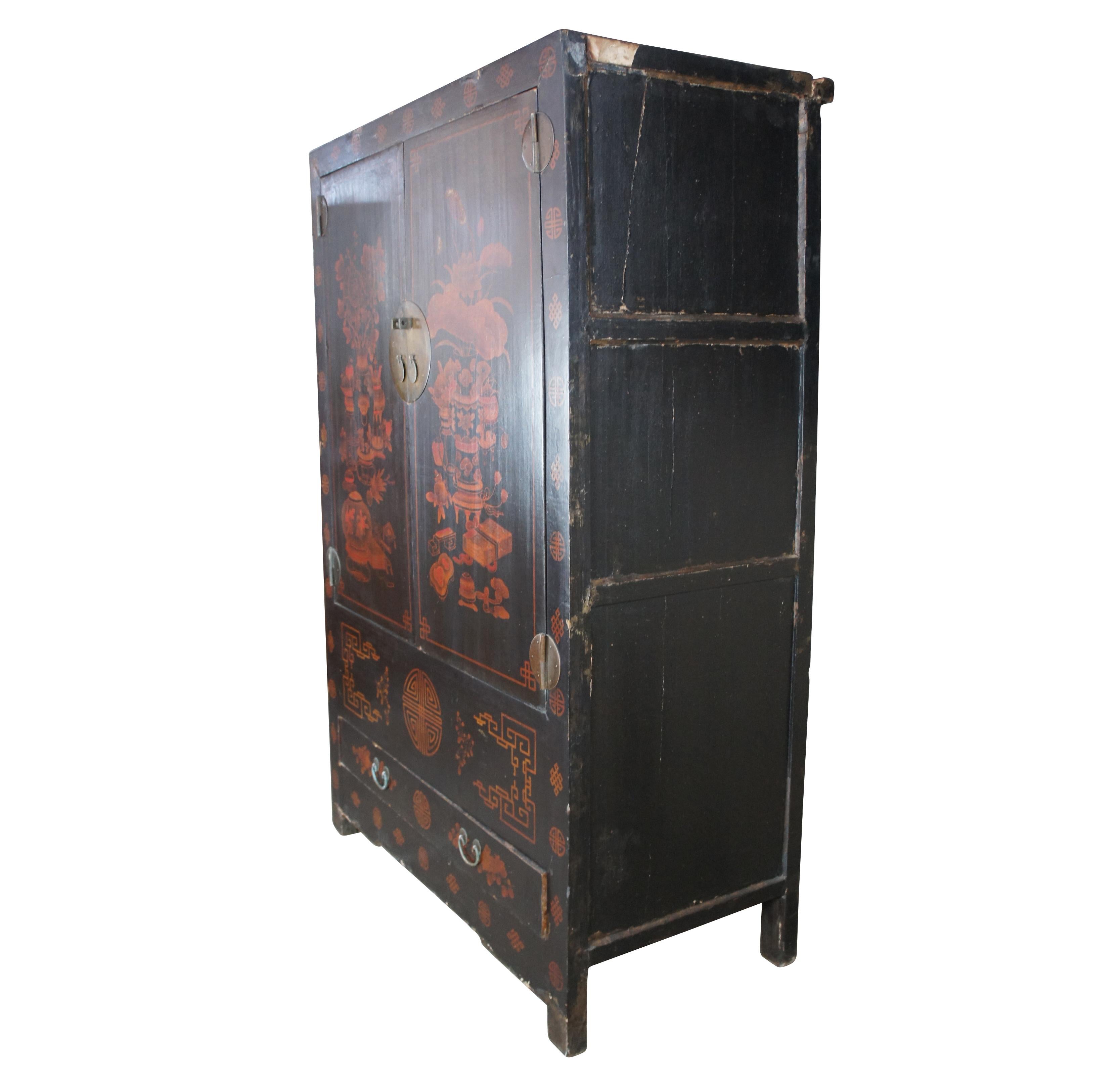 Monumental red over black lacquered Chinese cupboard, circa 1880s. Made from Elm with an artistic exterior featuring a scene of incense burners, censers, pots, ornate boxes and flowers along the doors. Frame is lined in alternating Chinese Greek key
