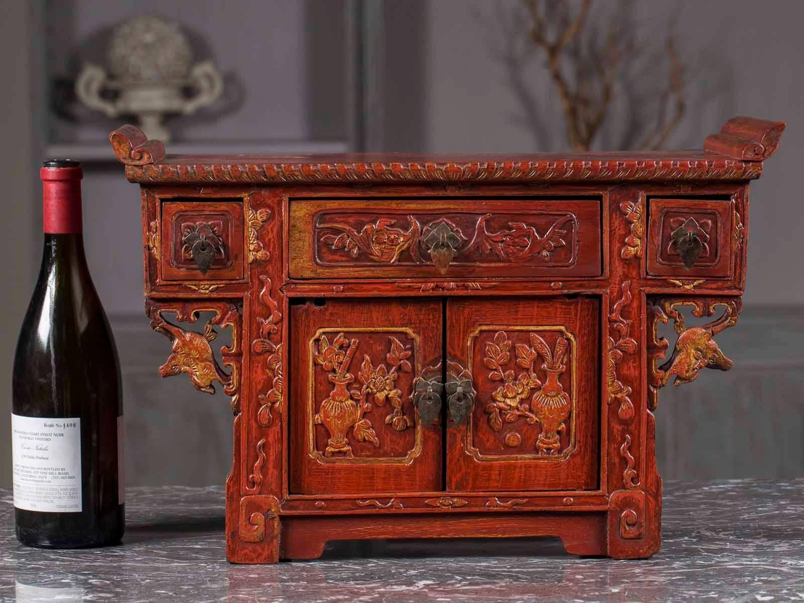 This miniature table top antique Chinese altar table buffet circa 1875 dates from the Kuang Hsu period and is correct in every detail to a full scale example. Please notice the lavish carved decoration and the red lacquer surface that retains traces