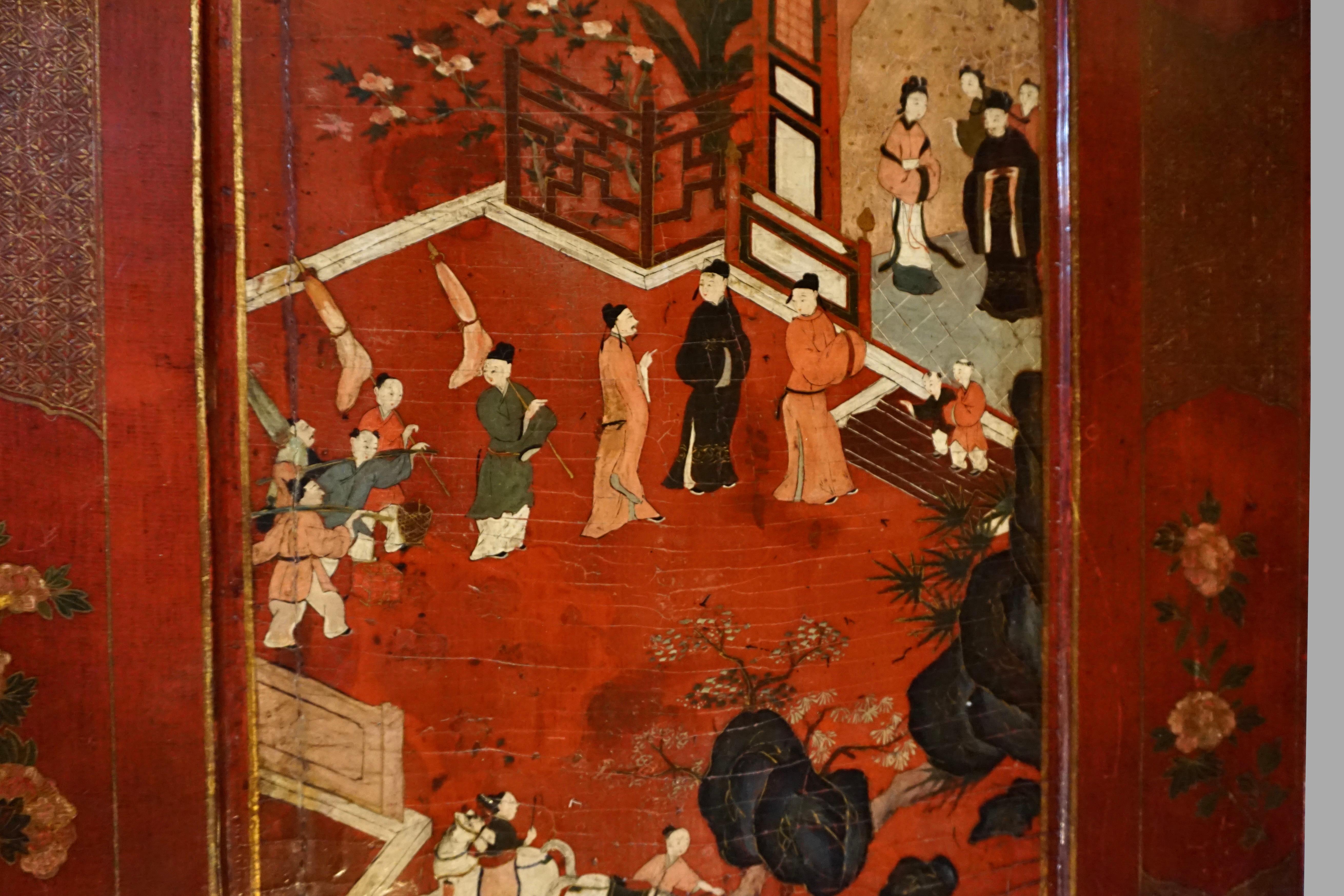 A beautiful Chinese red lacquer panel depicting court figures in a garden setting, the foreground with 2 women and horses, the center with a group of people waiting to enter a structure. The panel has been later mounted in a floral decorated custom