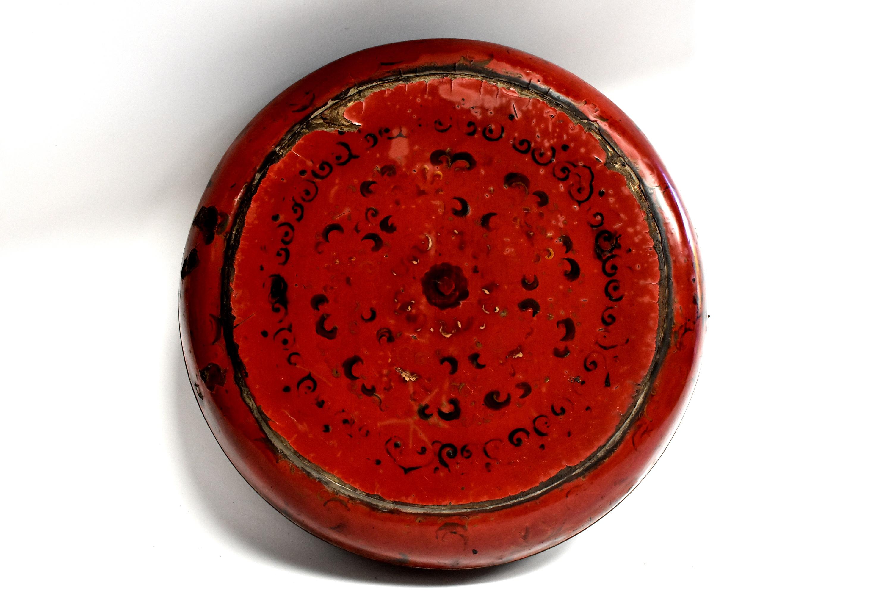 A beautiful ancient red lacquered round box with original paintings. The remnants of the top's elaborate painting of flowers and scrolls remain visible. Box has a black lacquered interior. Areas of wear show many layers of construction. All