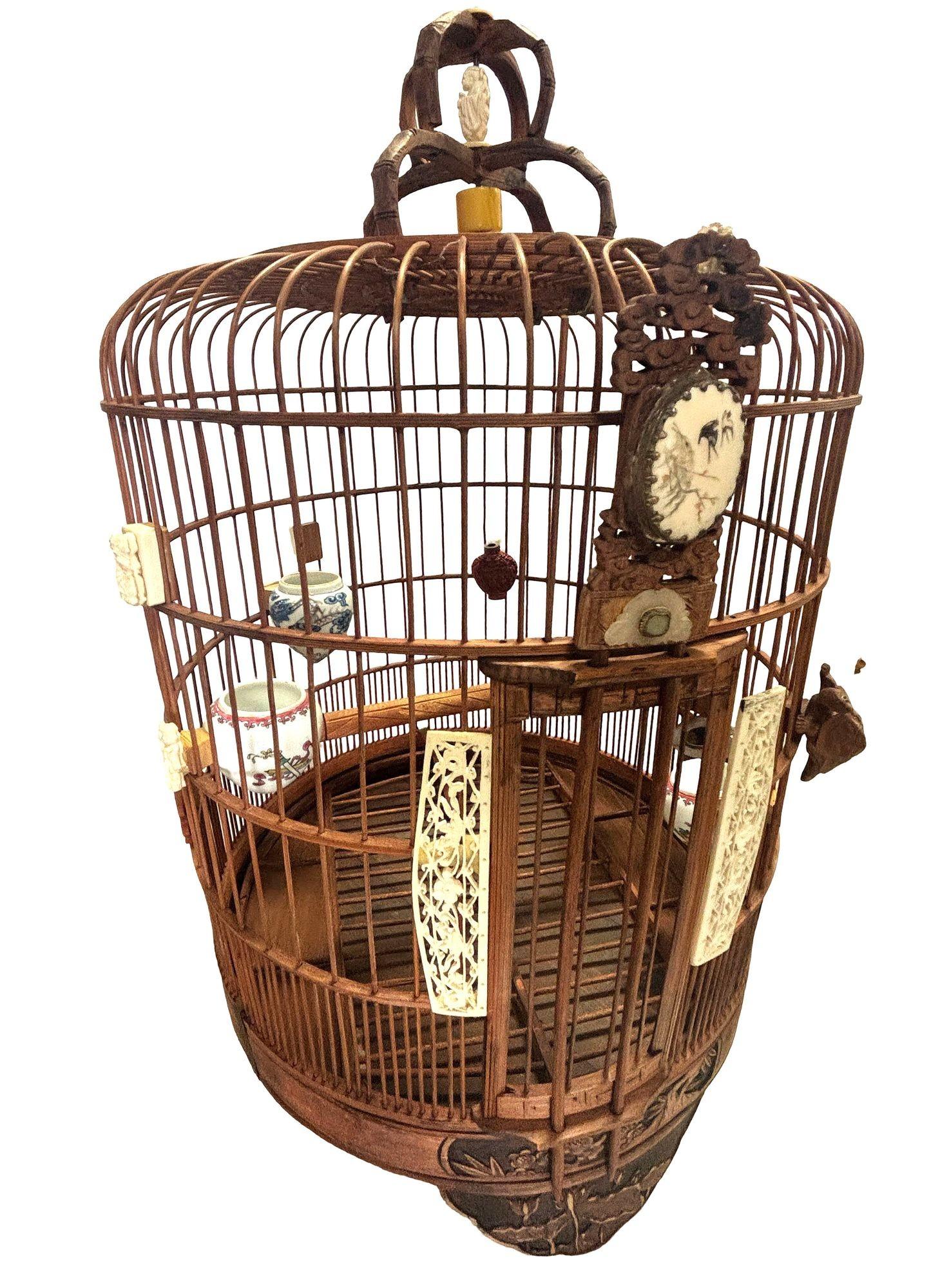 This antique Chinese birdcage, crafted from red reed rattan, features porcelain feeder bowls. Adorned with jade and mother-of-pearl accents, it showcases exquisite craftsmanship. A pin lock secures the cage, reflecting traditional design. This piece