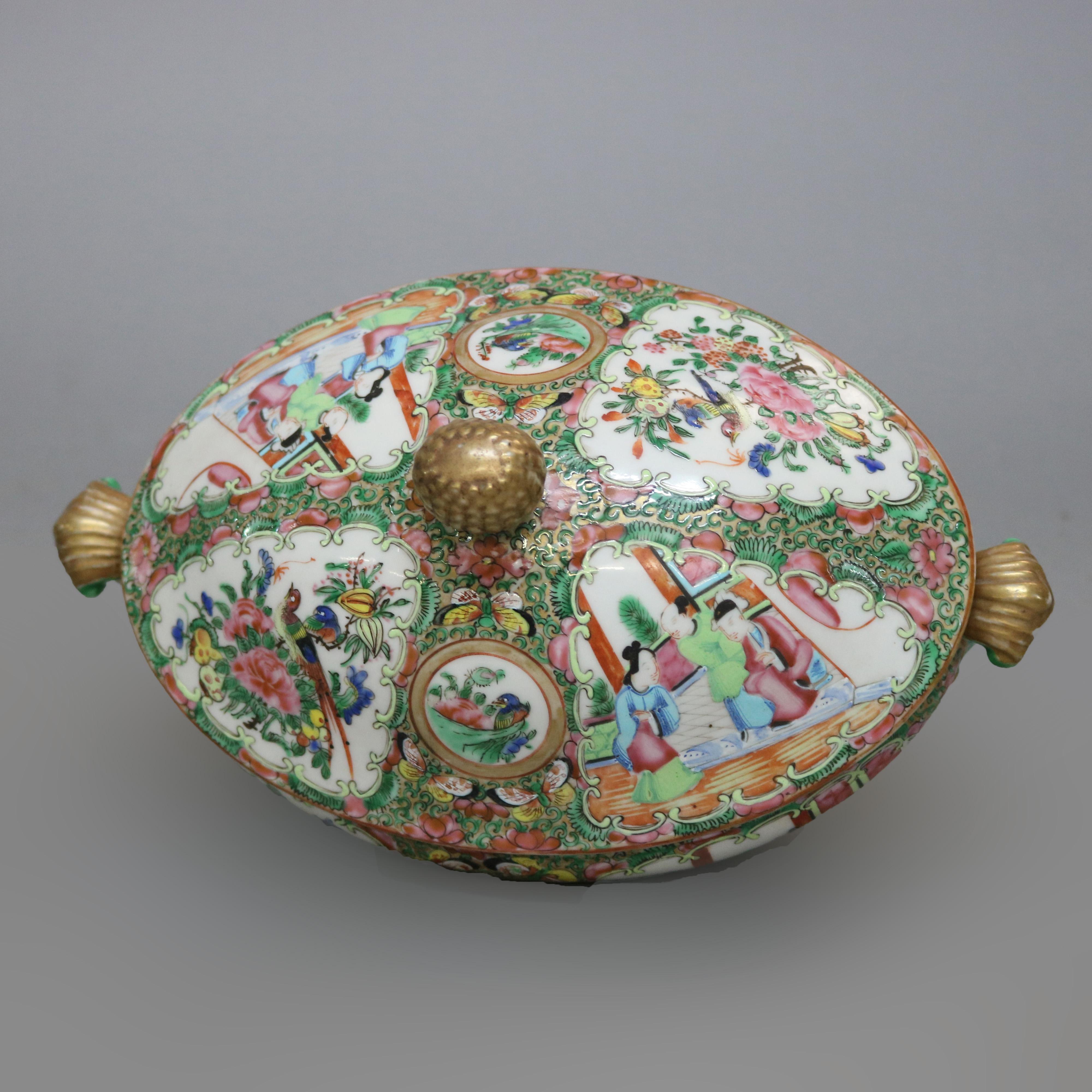 An antique Chinese Rose Medallion porcelain tureen offers gilt and beaded finial surmounting oval form floral and foliate lidded vessel having reserves (panels) with garden, bird, figure and genre scenes, flanking scrolled and gilt handles, raised