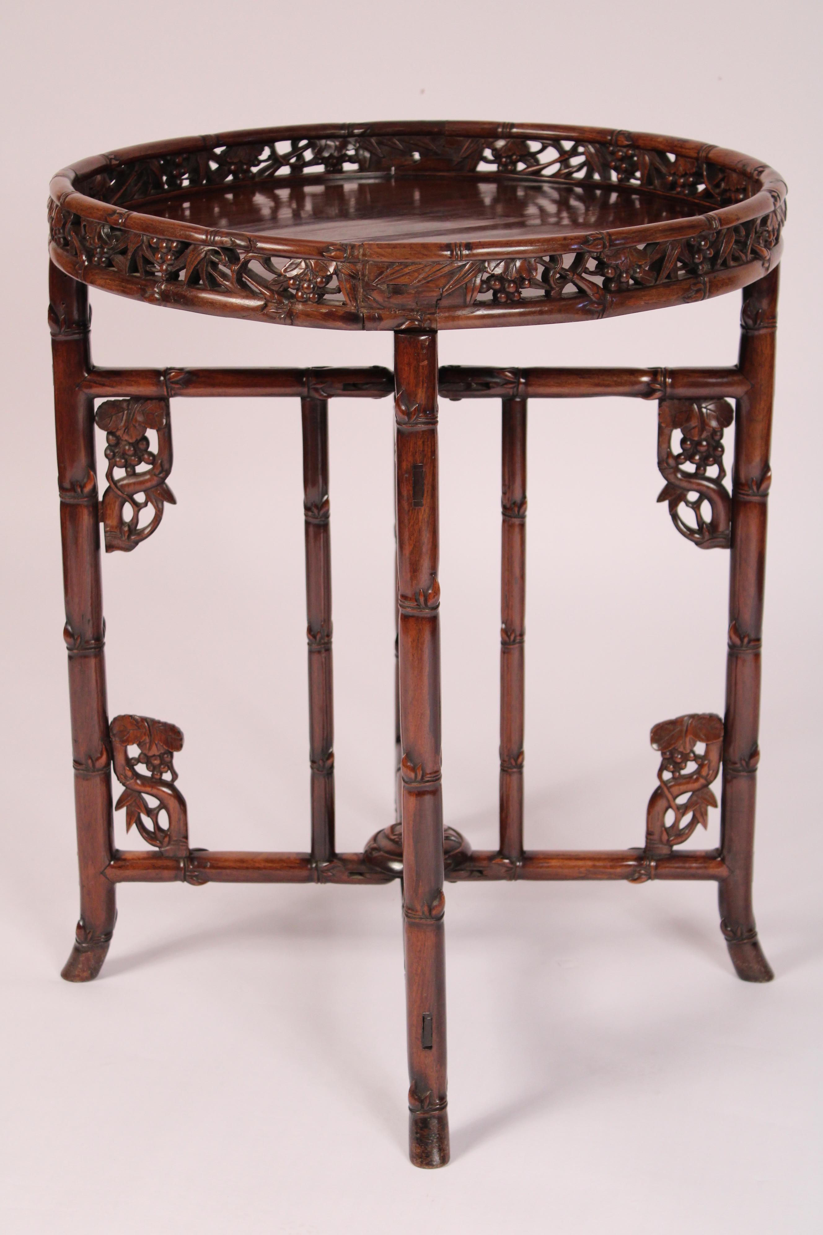 Table ronde chinoise en bois de rose, vers 1920. Avec une galerie sculptée et réticulée, reposant sur un support pliant avec une sculpture de style bambou. Belle couleur profonde et ancienne du palissandre. 