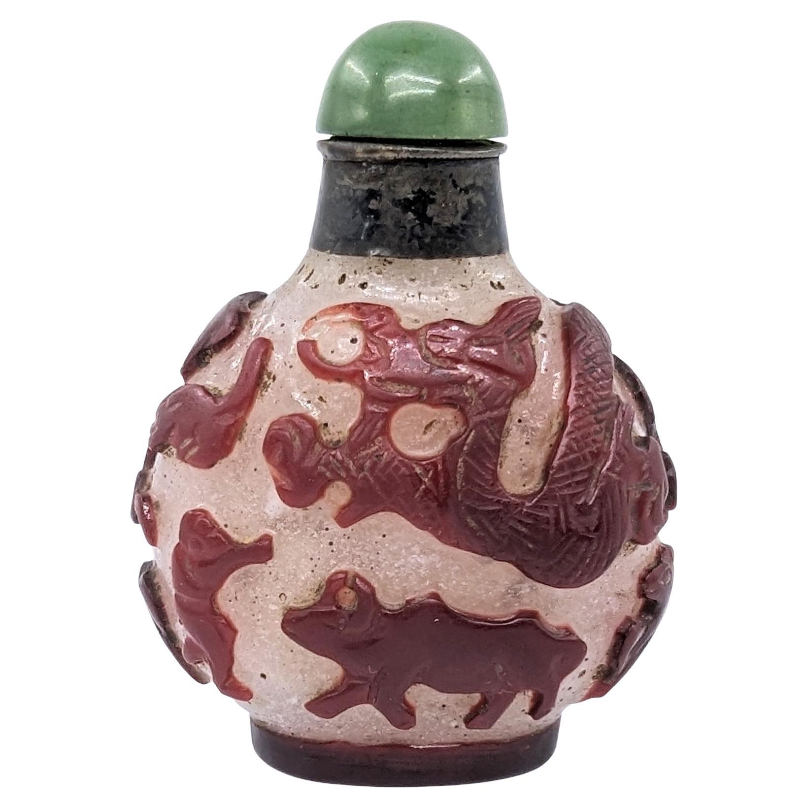 Antique Chinese ruby red carved glass overlay snuff bottle with 12 zodiac animals on snowstorm ground. Old repair to neck, green cabochon  jade stopper and spoon

19th Century, Qing Dynasty