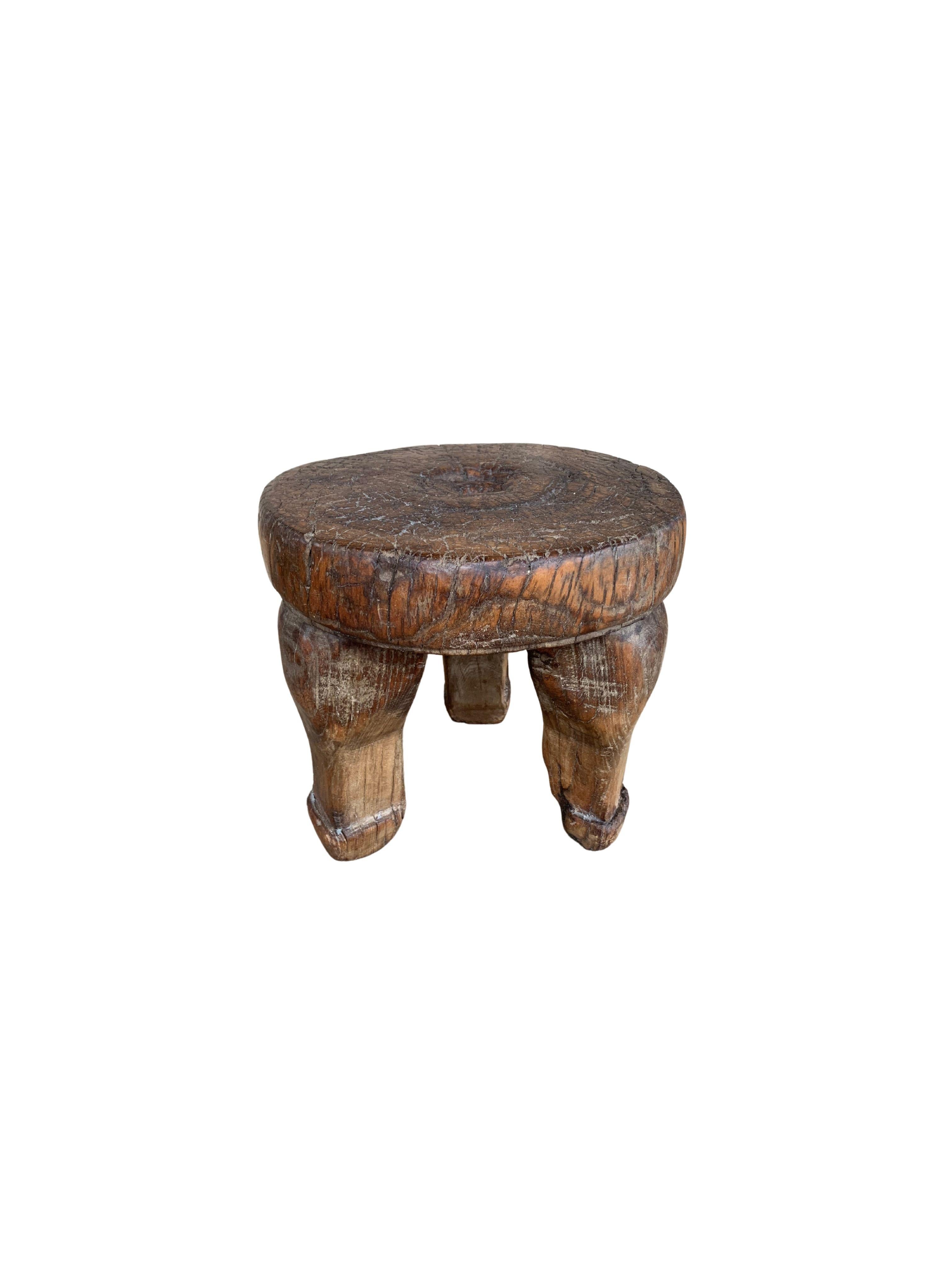 This Antique mini stool from the early 20th century features a beautiful age related patina and still retains some of its original lacquered finish. Crafted entirely from wooden joints, It remains sturdy and robust, a fantastic piece to use as a