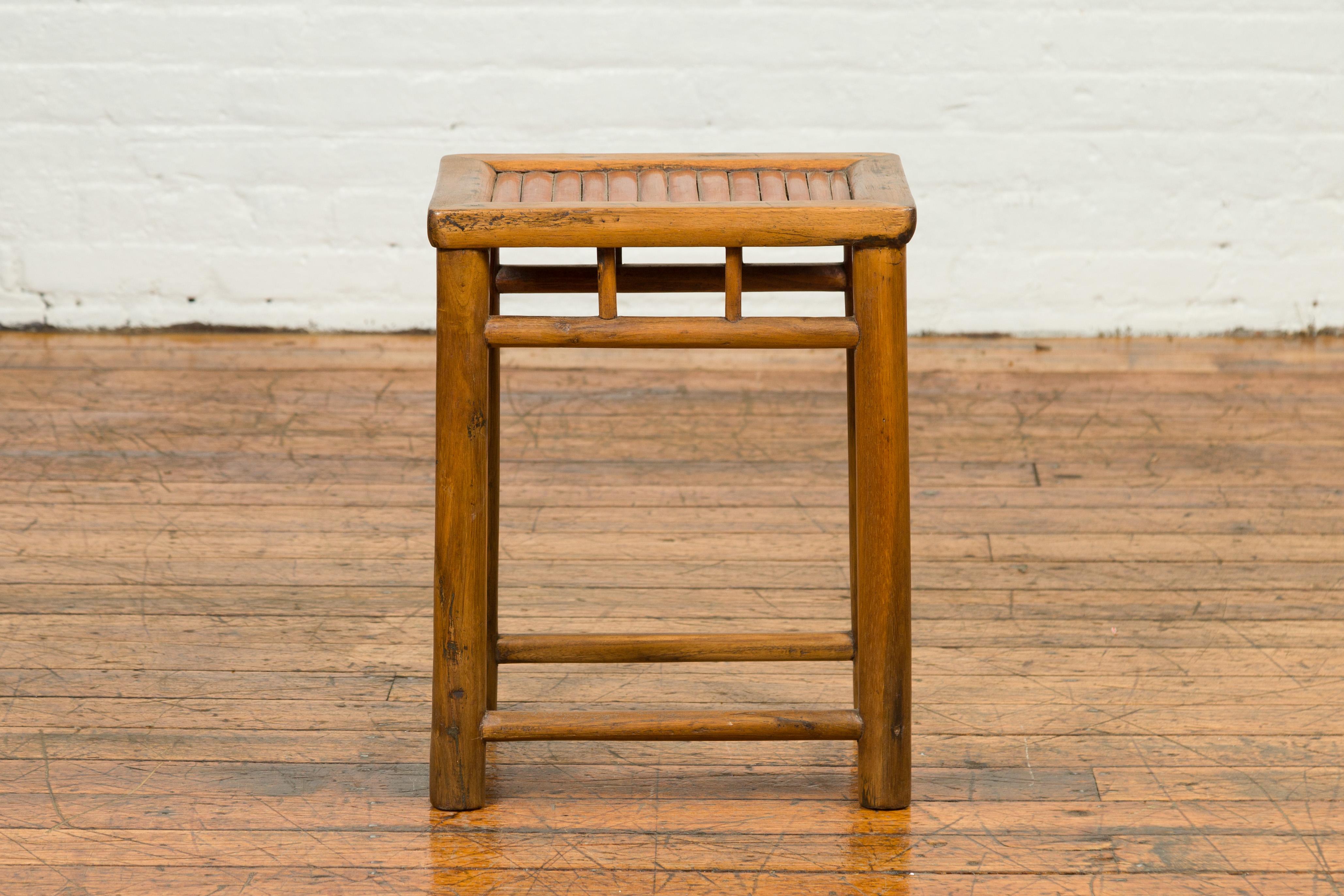 A Chinese antique rustic side table from the early 20th century, with bamboo inset. Created in China during the early years of the 20th century, this side table features rectangular top with bamboo inset, resting upon a simple base made of