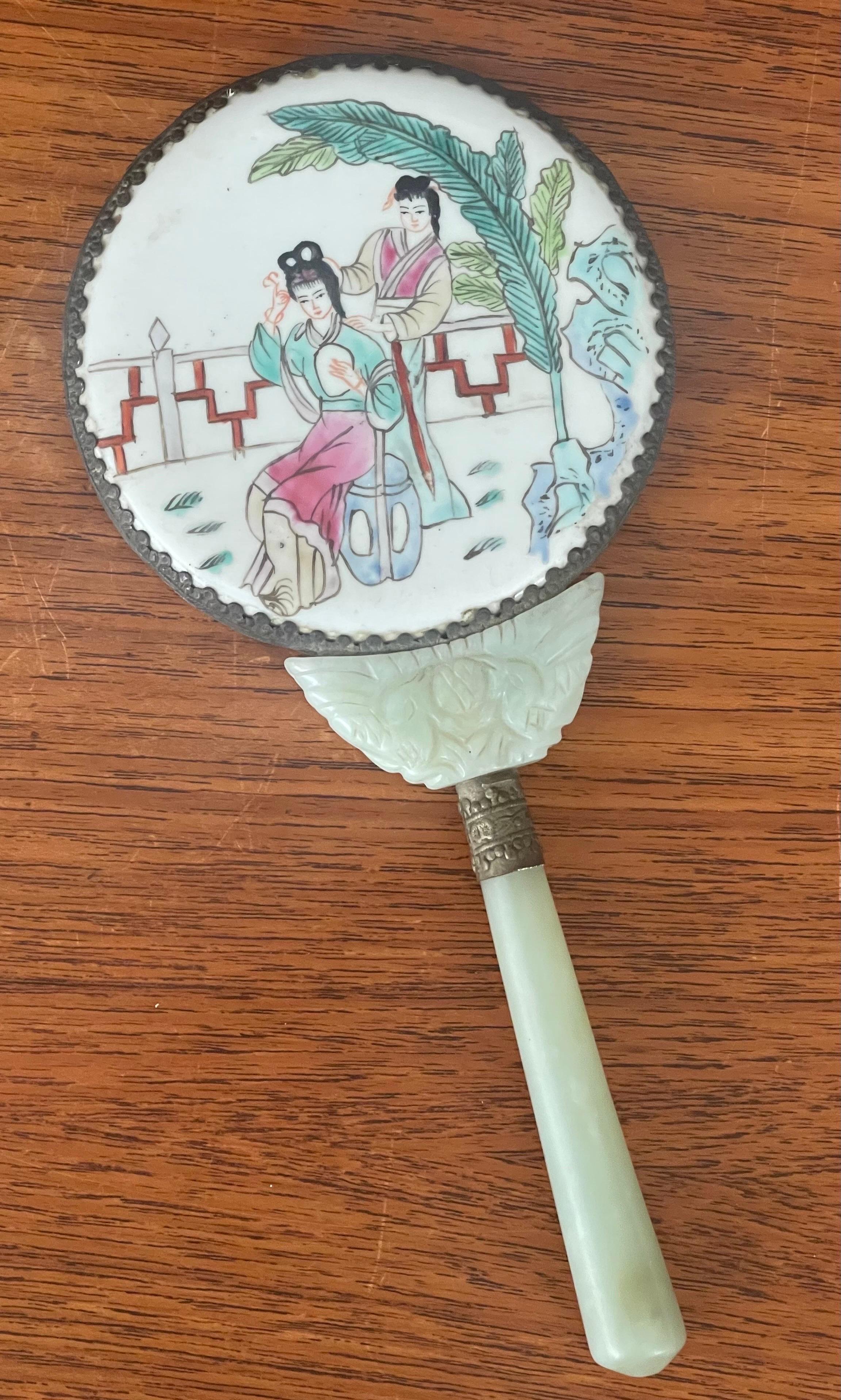 A nice antique Chinese serpentine / jade with hand painted porcelain hand mirror, circa 1910s to 1920s. The mirror is beautifully hand crafted from either serpentine (a stone often mistaken for jade) or jade itself (I am not an expert and honestly