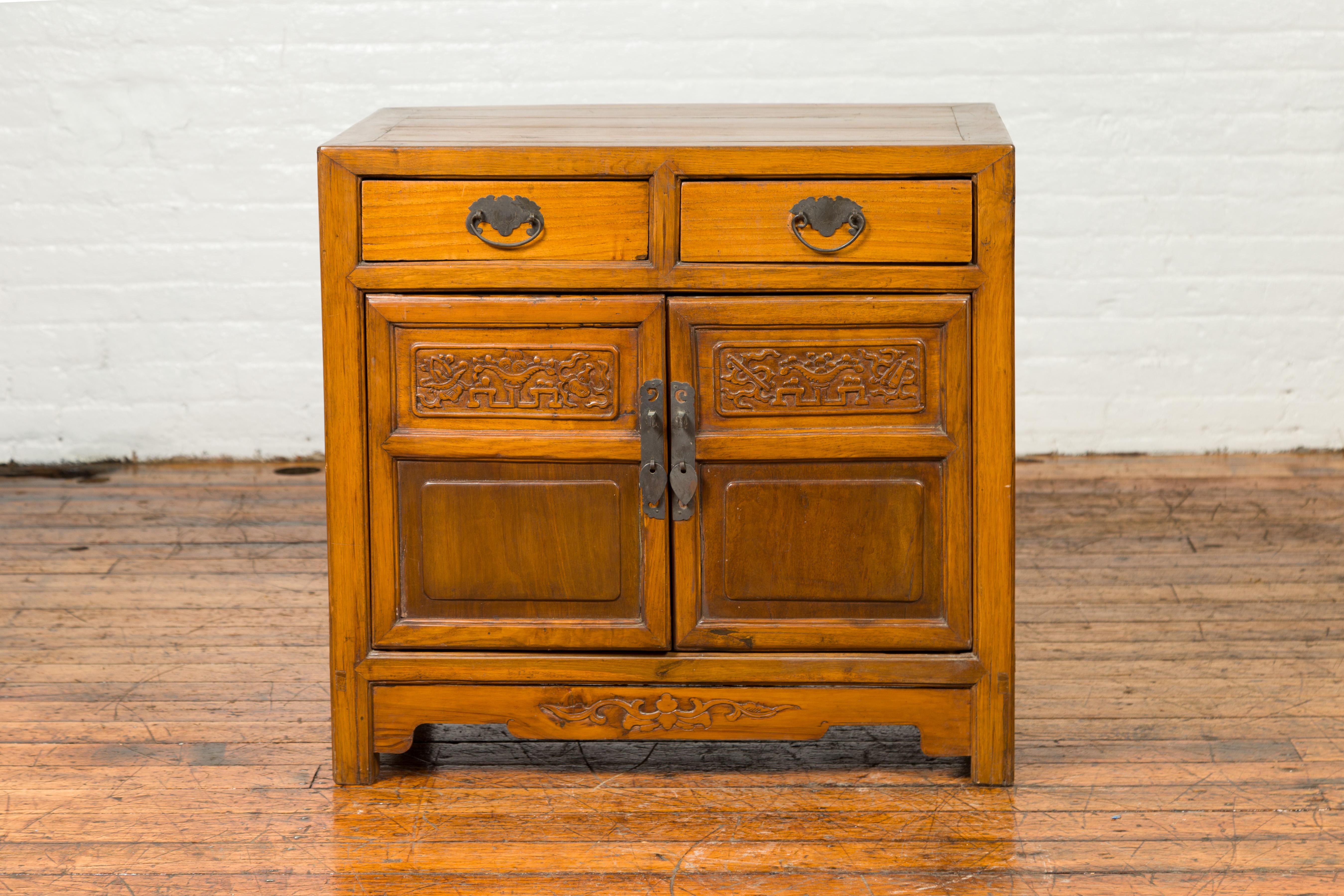A late Qing Dynasty side chest from the early 20th century, with two drawers, carved motifs and double doors. This late Qing Dynasty Chinese side chest encapsulates the refined craftsmanship and aesthetic sensibilities of the period. With a