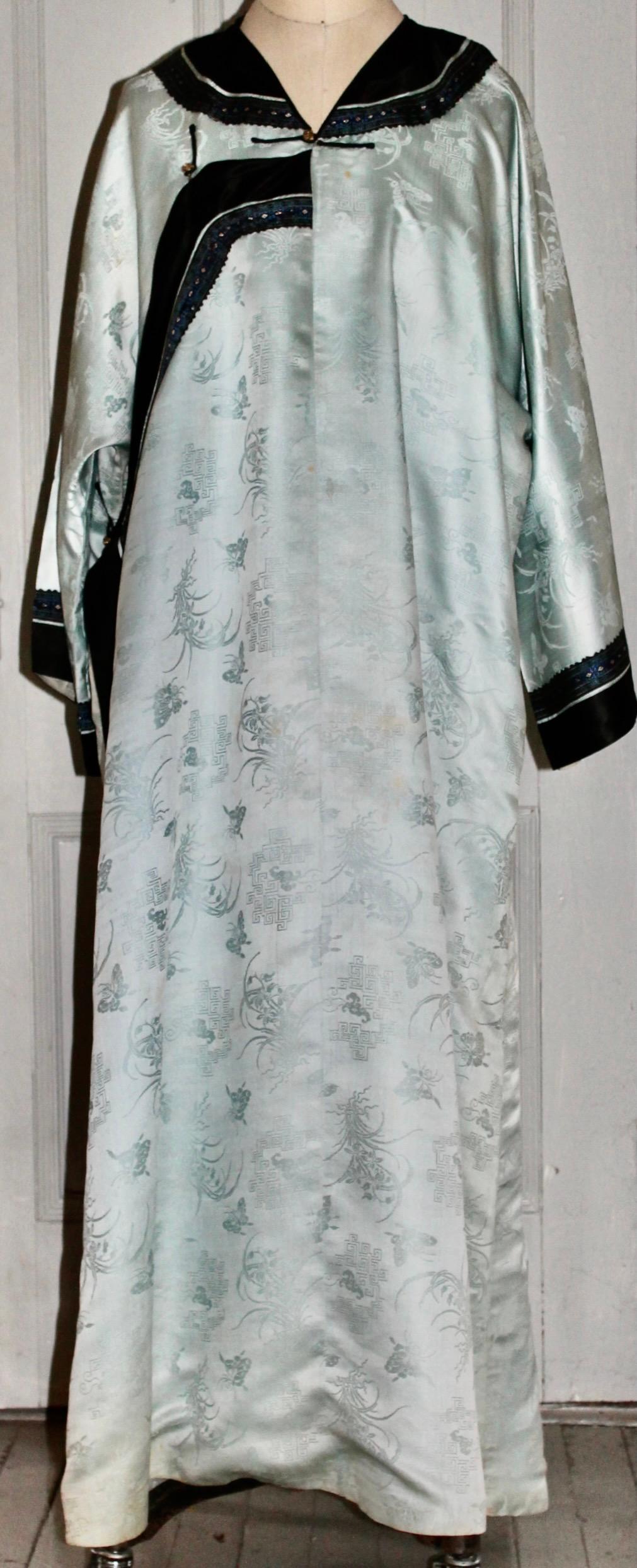 Offering an Antique Chinese Silk Kimono, patterned light blue
silk, with a lining in white silk.  Embroidered applied border at sleeves and neckline.  Total length 52
