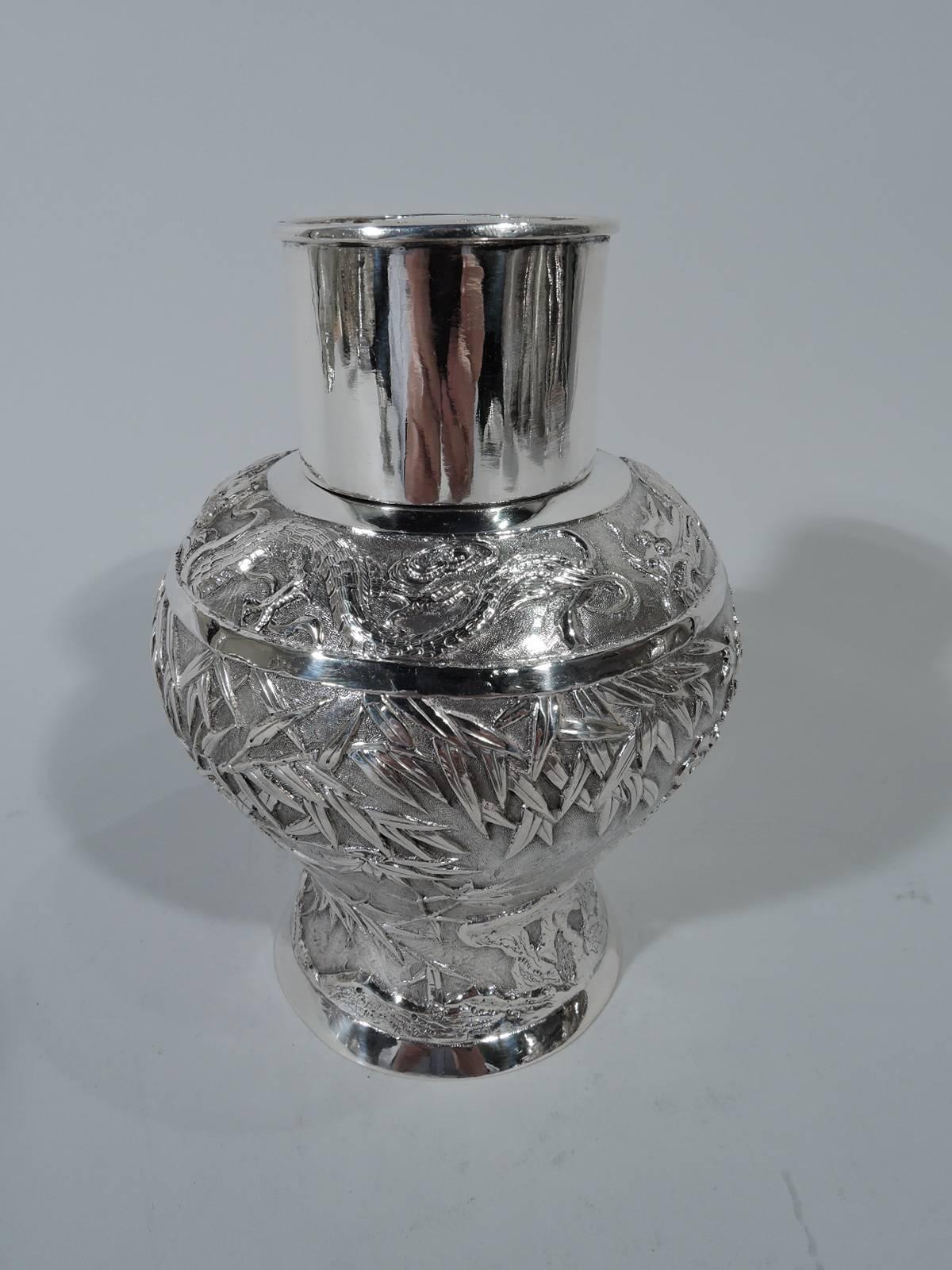 Chinese export silver tea caddy, circa 1900. Baluster with drum-form neck and cover. Chased and repousse bamboo and blossoming prunus branches on stippled ground. Plain band at shoulder. Also plain are foot rim, neck, and cover sides. Cover top has