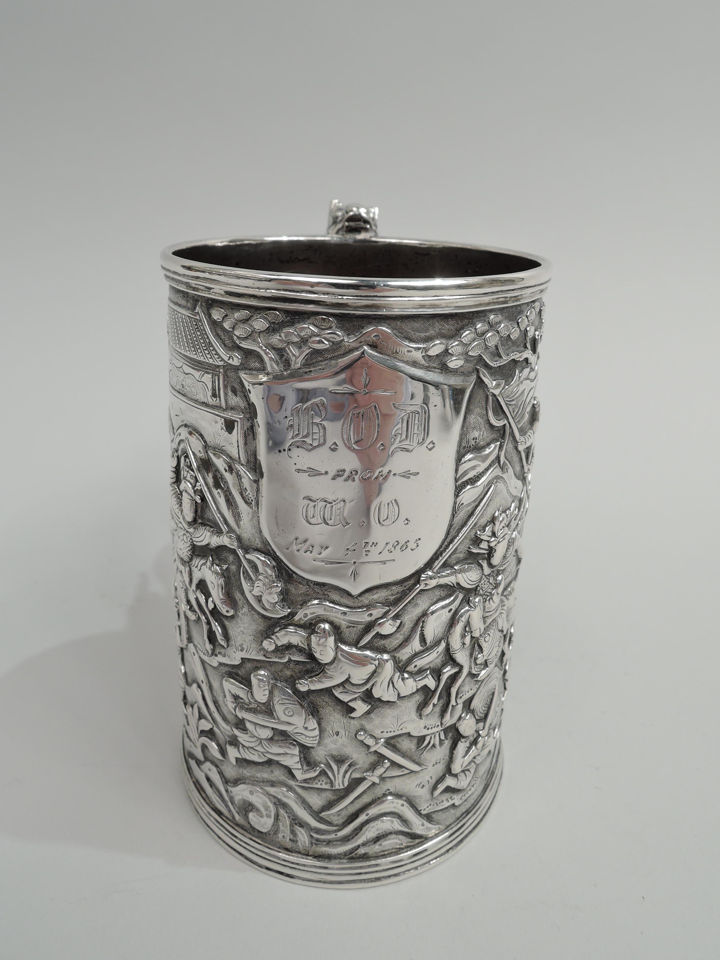 Chinese silver mug, ca 1865. Straight and upward tapering sides with dense low-relief frieze: Spearmen and swordsmen on foot and horse thrust and lunge and, in some cases, fall in battle. Applied armorial shield with engraved presentation dated “May