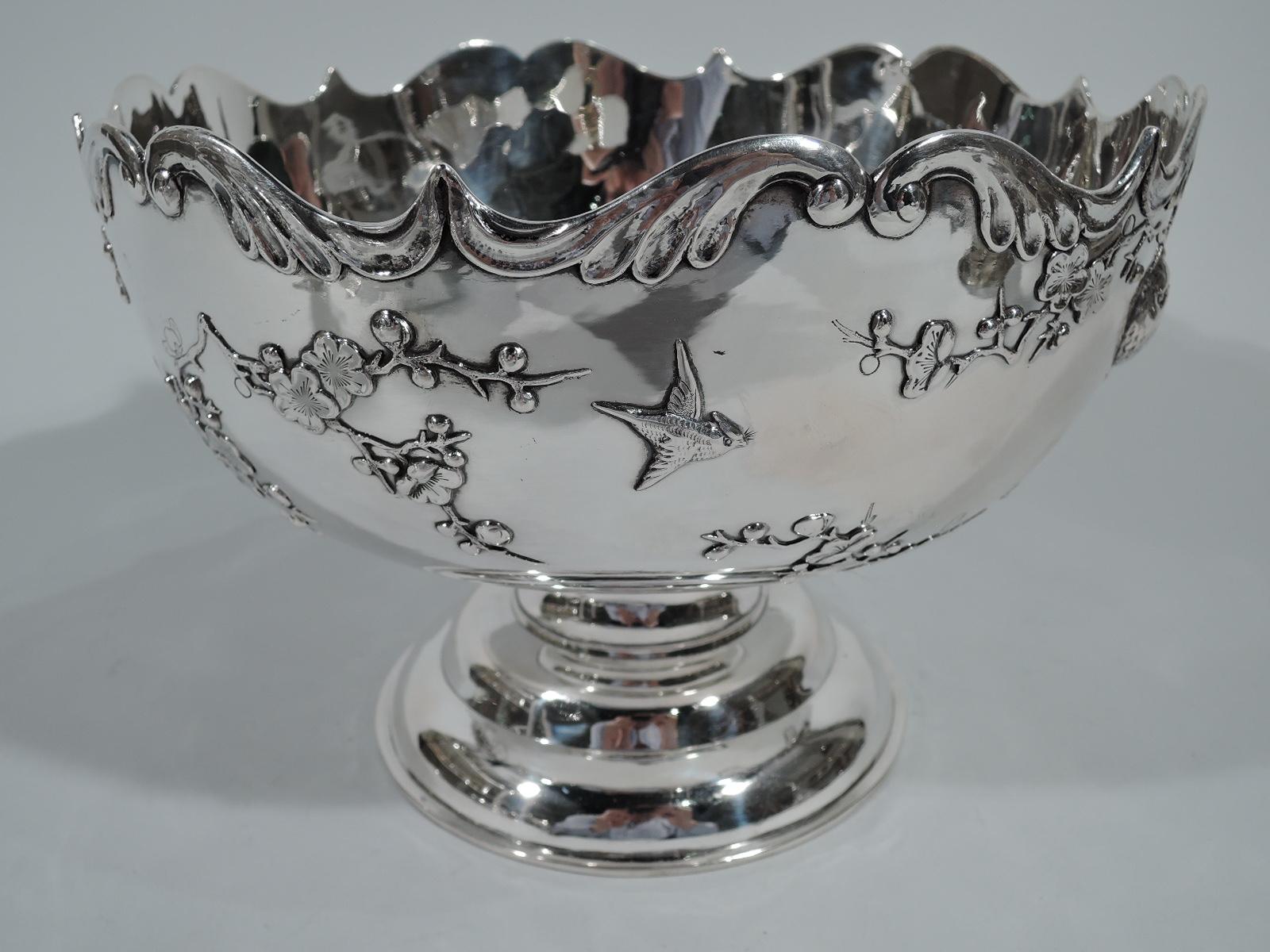 Chinese export silver bowl, circa 1900. Curved sides with scrolled rim, short spool support, and round stepped foot. Spare and elegant ornament applied to bowl exterior: Birds fly and perch on blossoming prunus branches. Nice depiction of the