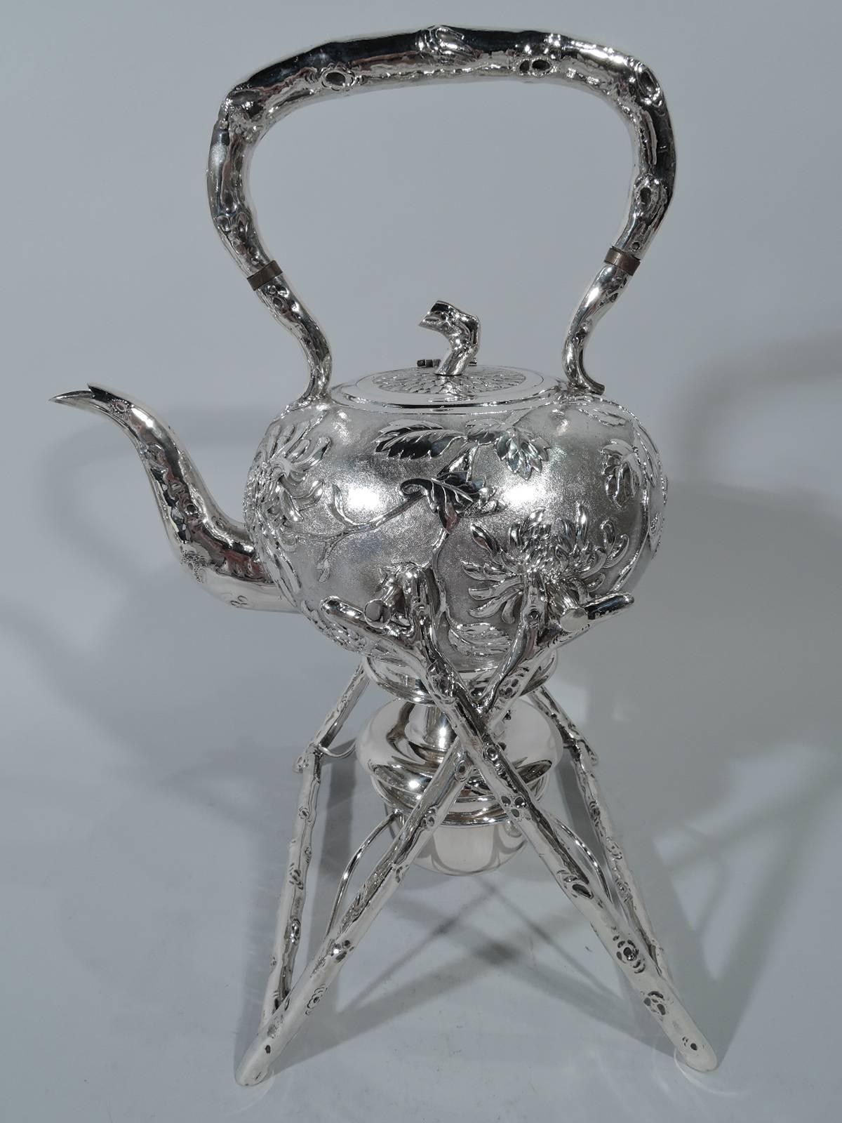 Chinese export silver tea set with modish chrysanthemum motif, circa 1900. This set comprises hot water kettle on stand, teapot, creamer, and sugar. Each: Globular with flowers on stippled ground. Kettle and teapot have S-form spout. Creamer has