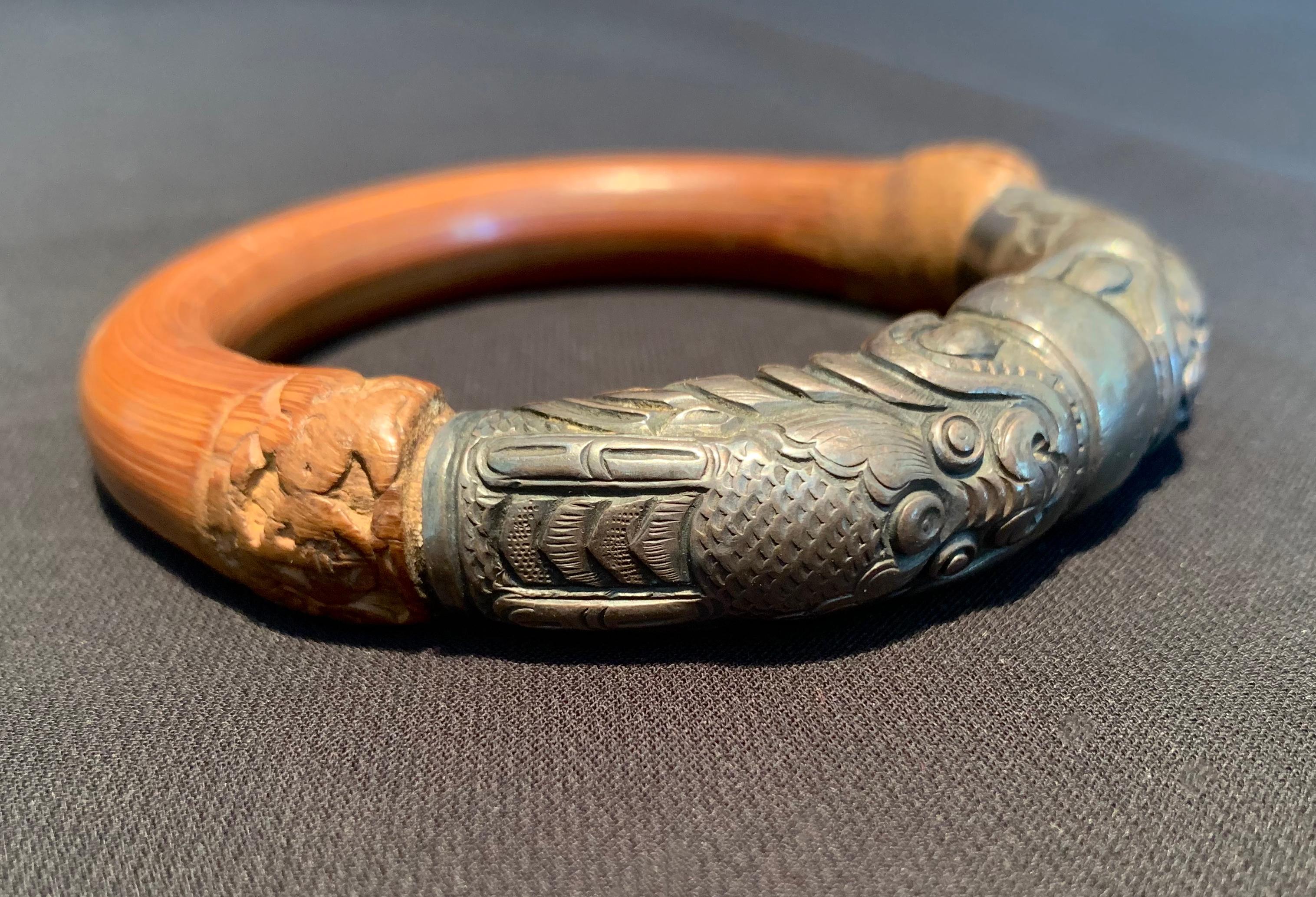 This antique Chinese silver and rattan bamboo bracelet features a double headed dragon holding a globe. It required intricate detail and skilled craftsmanship which would have taken a great number of hours to complete. 

Dimensions: Inner