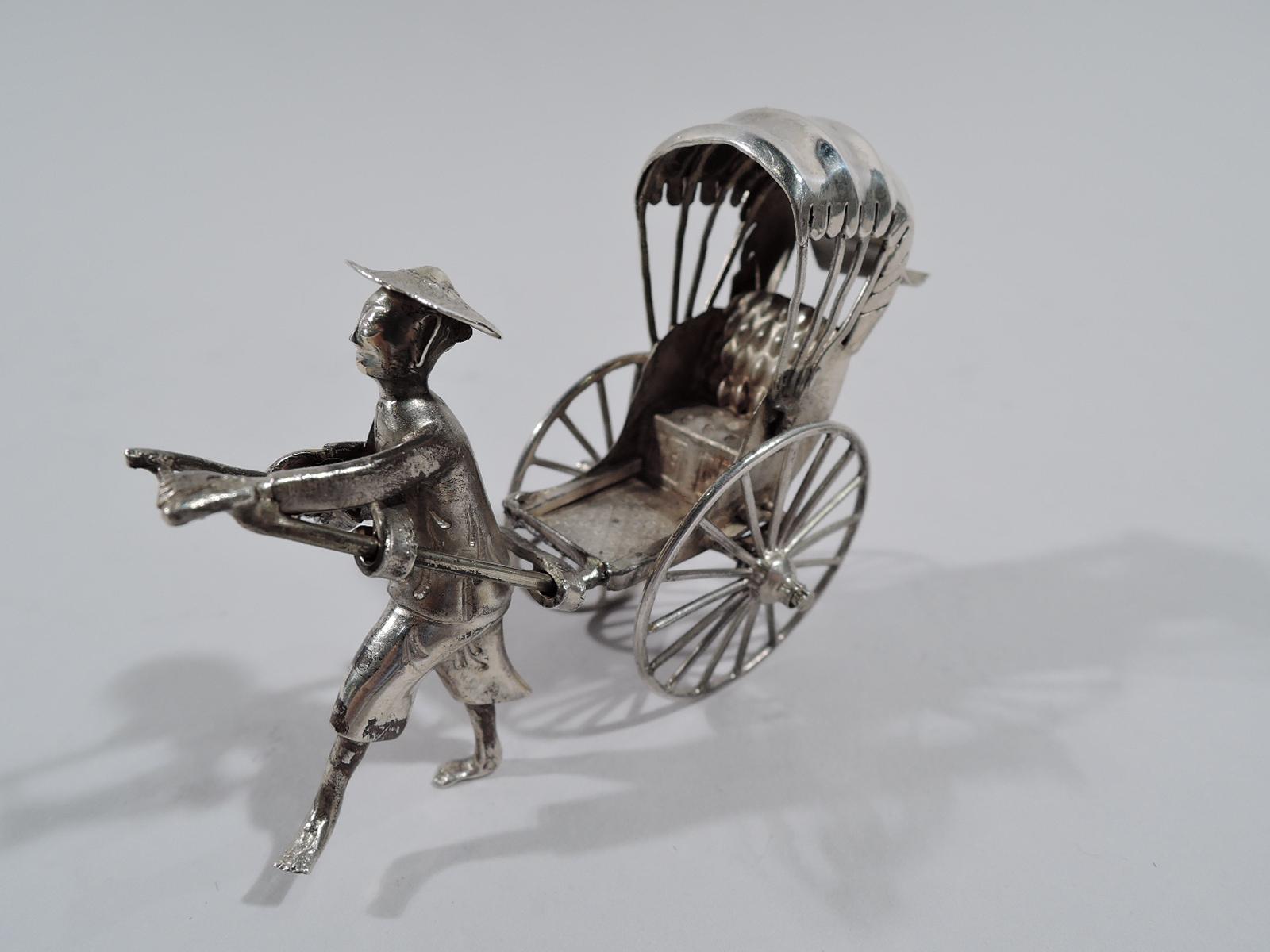 Pousse-pousse miniature chinois en argent, vers 1920. Un véhicule à deux roues attelé à un coureur aux pieds nus portant un chapeau de paille. Une décoration de fête amusante. Les roues tournent pour permettre de piloter autour de la table après