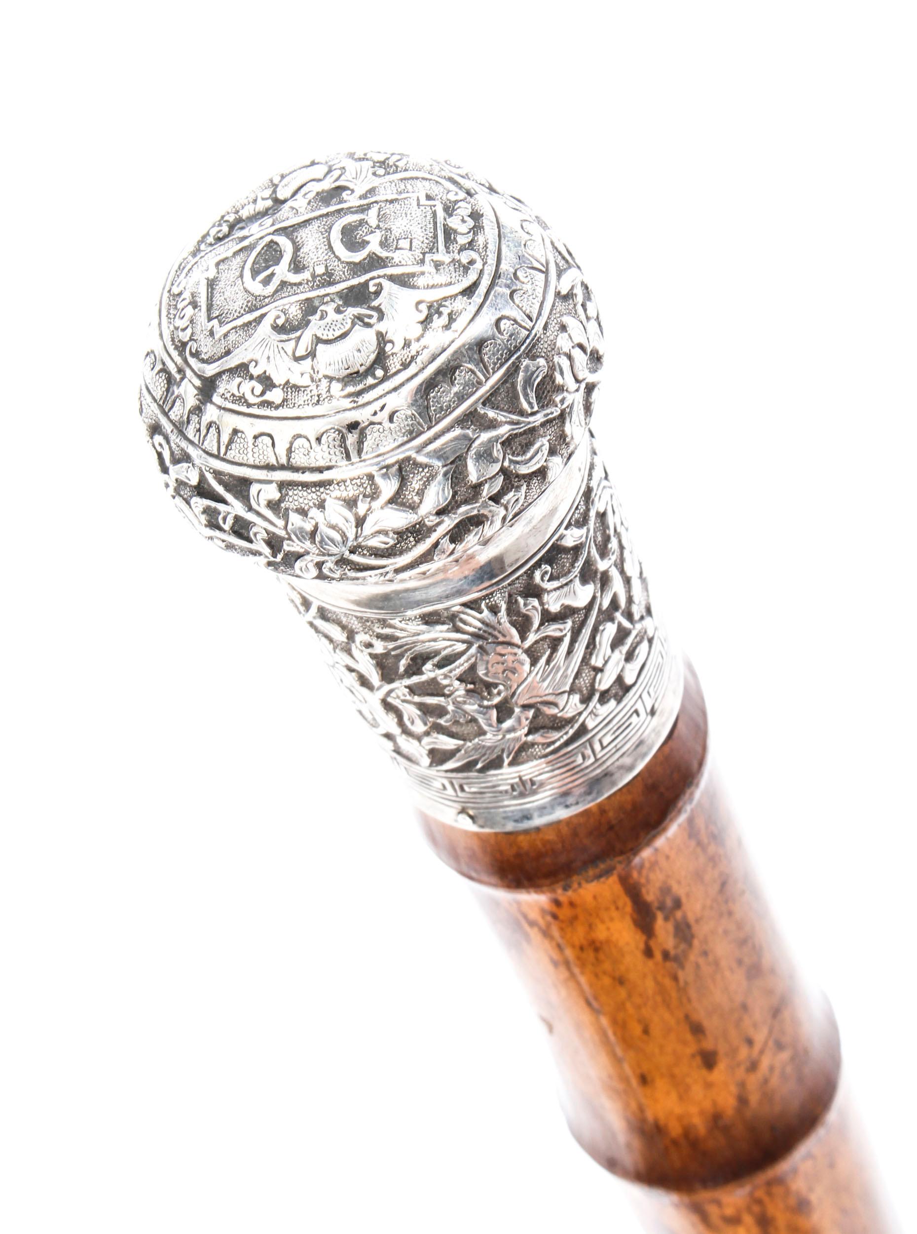 This is a beautiful antique Chinese gentleman's silver pommel walking stick, circa 1880 in date.

This decorative walking cane features an exquisite Chinese silver pommel decorated with exquisitely chased blossoming flowers including lotus and