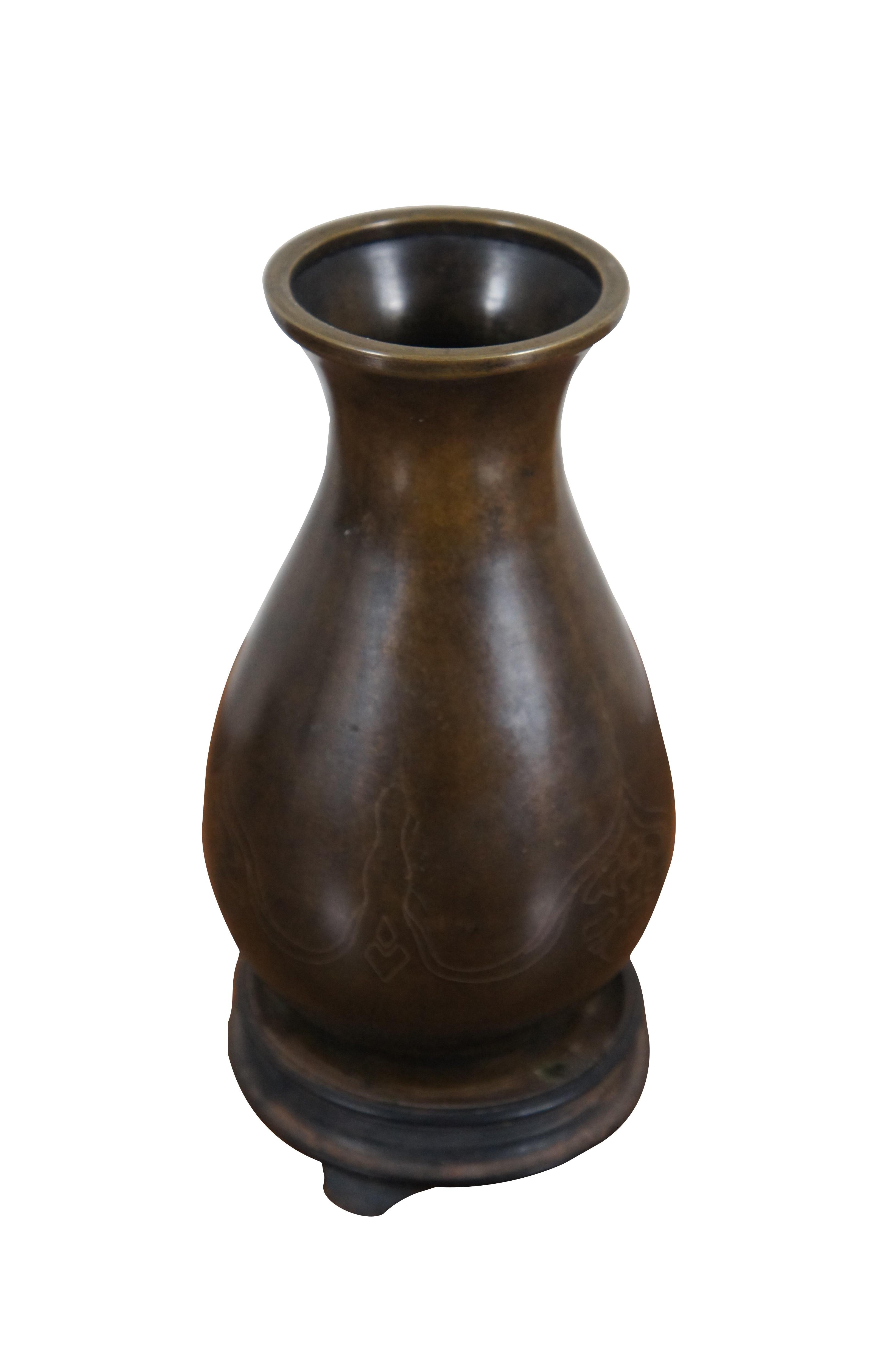 Antique silver wire inlaid bronze cloisonné vase. Features a slightly mottled brown finish with a simple sparse design in inlaid silver wire. Includes wooden stand.

Dimensions:
4.25