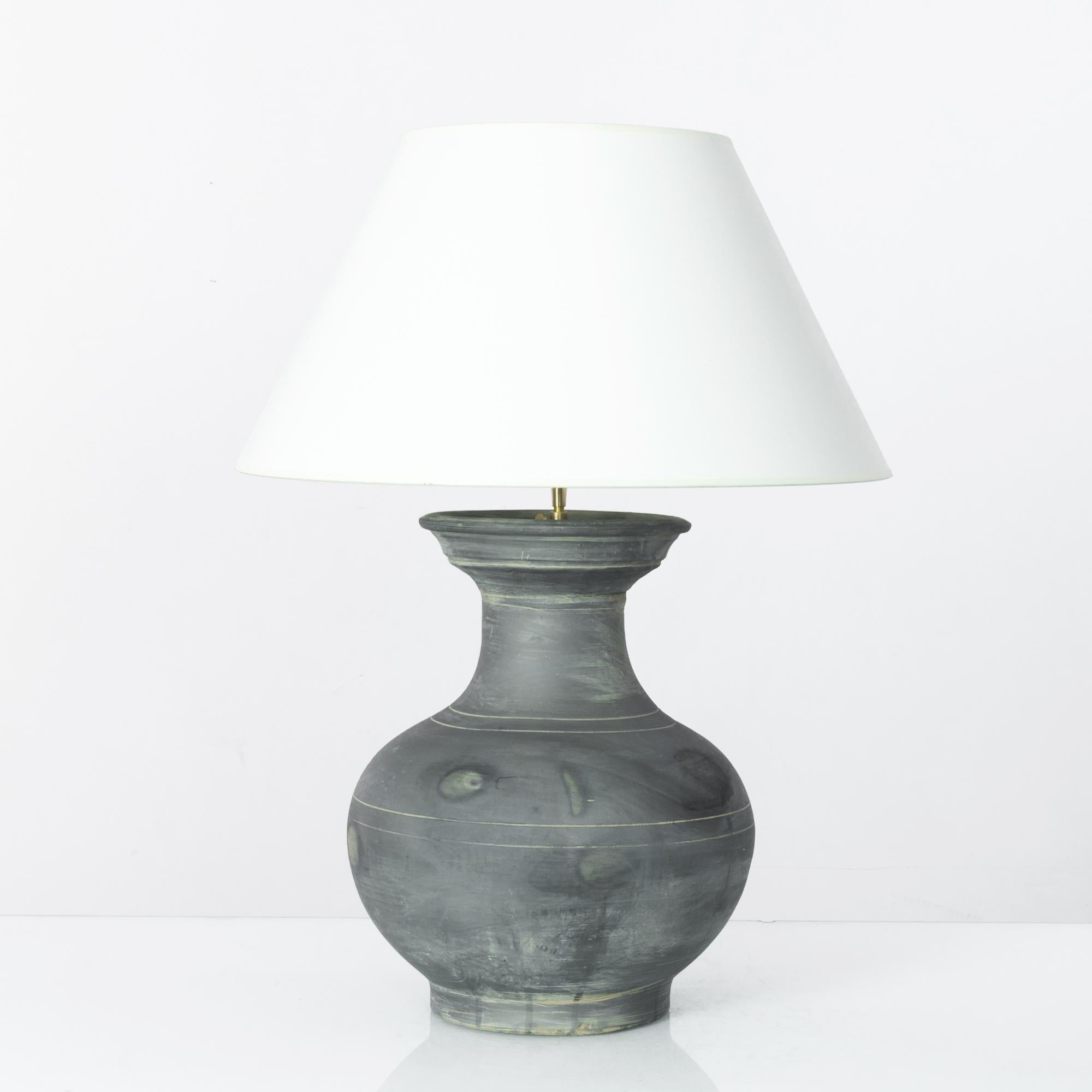A vintage Chinese vase, fitted with an adjustable brass fixture and E26 lighting socket. The smoky grey glaze and incised lines create a vivid visual impact. Textured glazes, attractive colors and organic shape grants a sensuous tactility to the