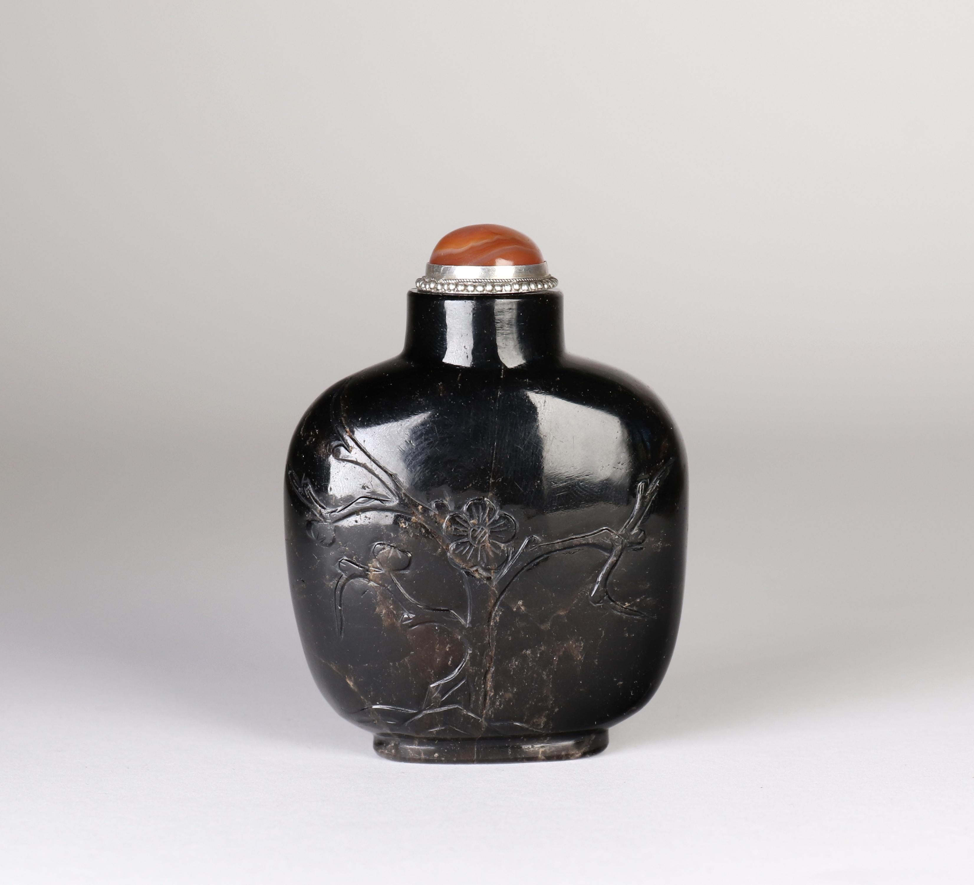 Antigua botella de rapé de piedra dura negra tallada a mano de mediados de la dinastía Qing.

Producido en China hacia finales del siglo XIX.

Hermosa forma con cuerpo y hombros fuertes. 

Muy bien ahuecado, hasta los bordes, cuando lo atraviesas