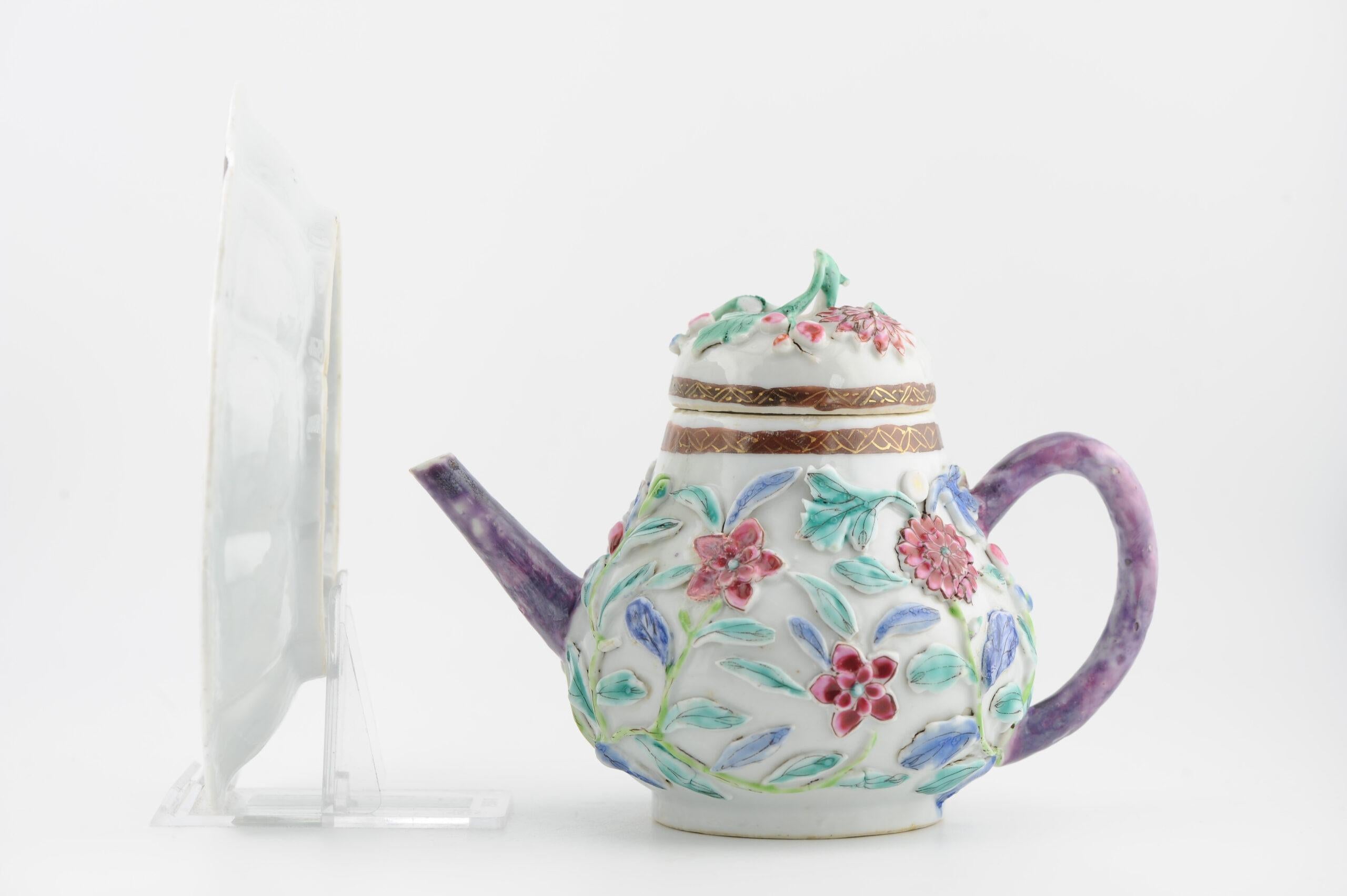 A charming late Yongzheng period famille rose teapot, with an elegant elongated body tapering to a bulging lower belly, and modeled with aubergine enameled handles simulating the look of tree limbs. The lid and body is appliqué-decorated with