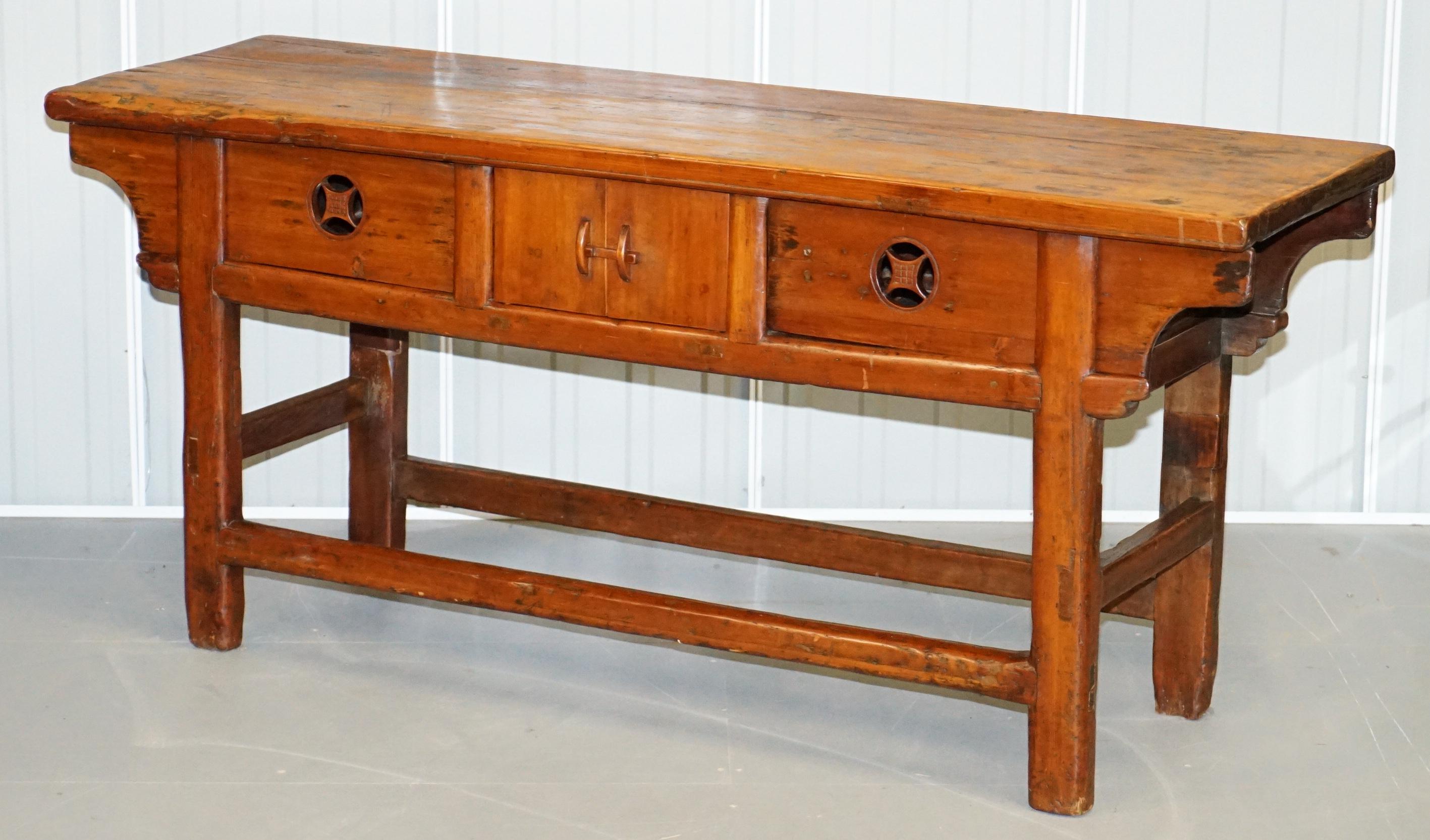 We are delighted to offer for sale this lovely vintage Chinese alter sideboard with original finish

A very good looking and naively made antique sideboard. Its hand carved from solid slabs of teak, the finish is distressed, the top bowed towards