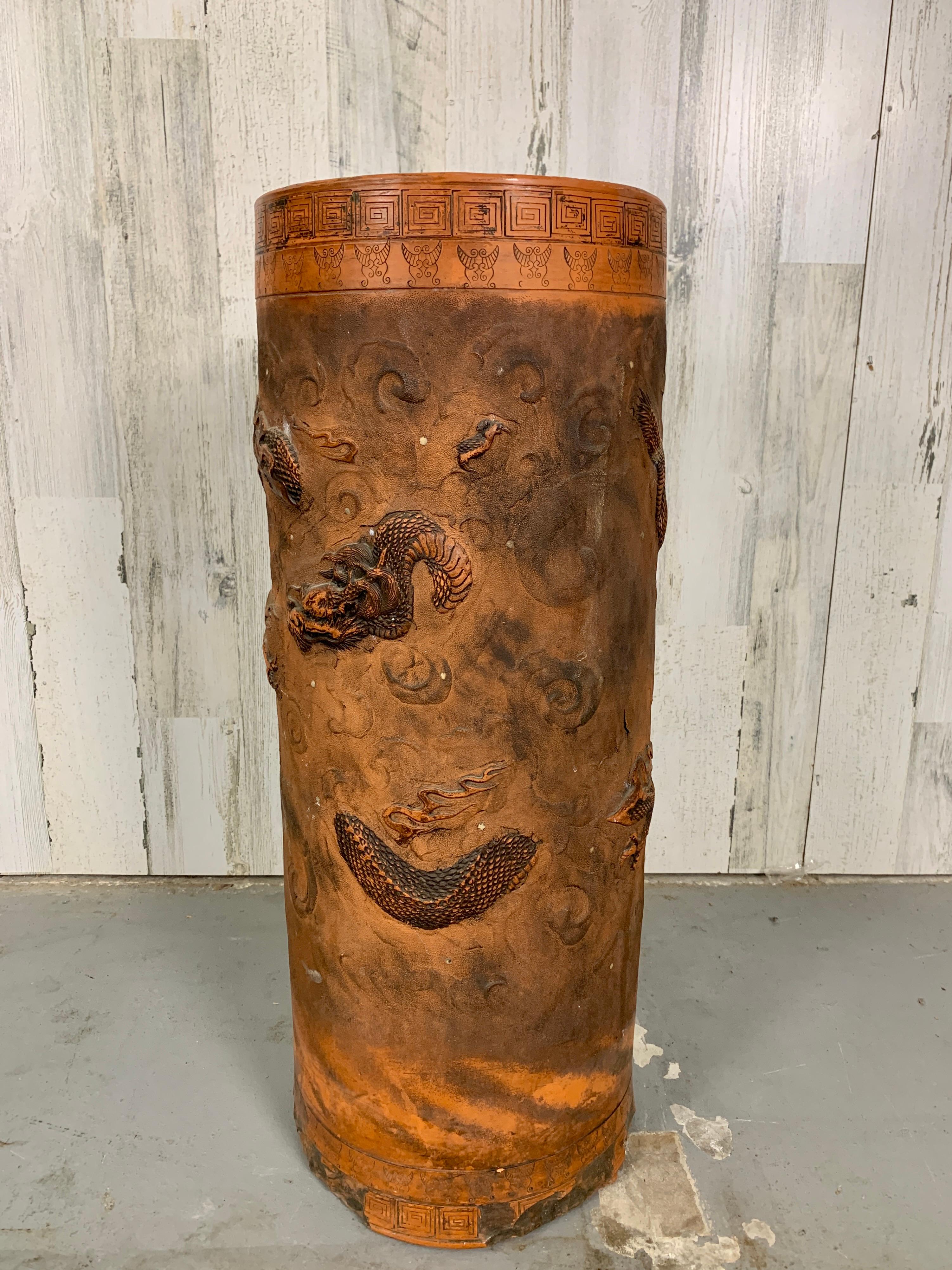Early 20th century Terra cotta stand is hand crafted with paint along the Greek key boarder and on the dragons. On the bottom is a crossed flag stamp, the makers mark..