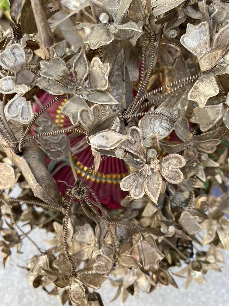 This is a rare Antique Chinese wedding crown hand made of Chinese silver.
Hand made flowers, birds leaves, etc. all surrounding a pill box hat of dark red.

The story goes. Patients of the bride at the time she was born, started saving their