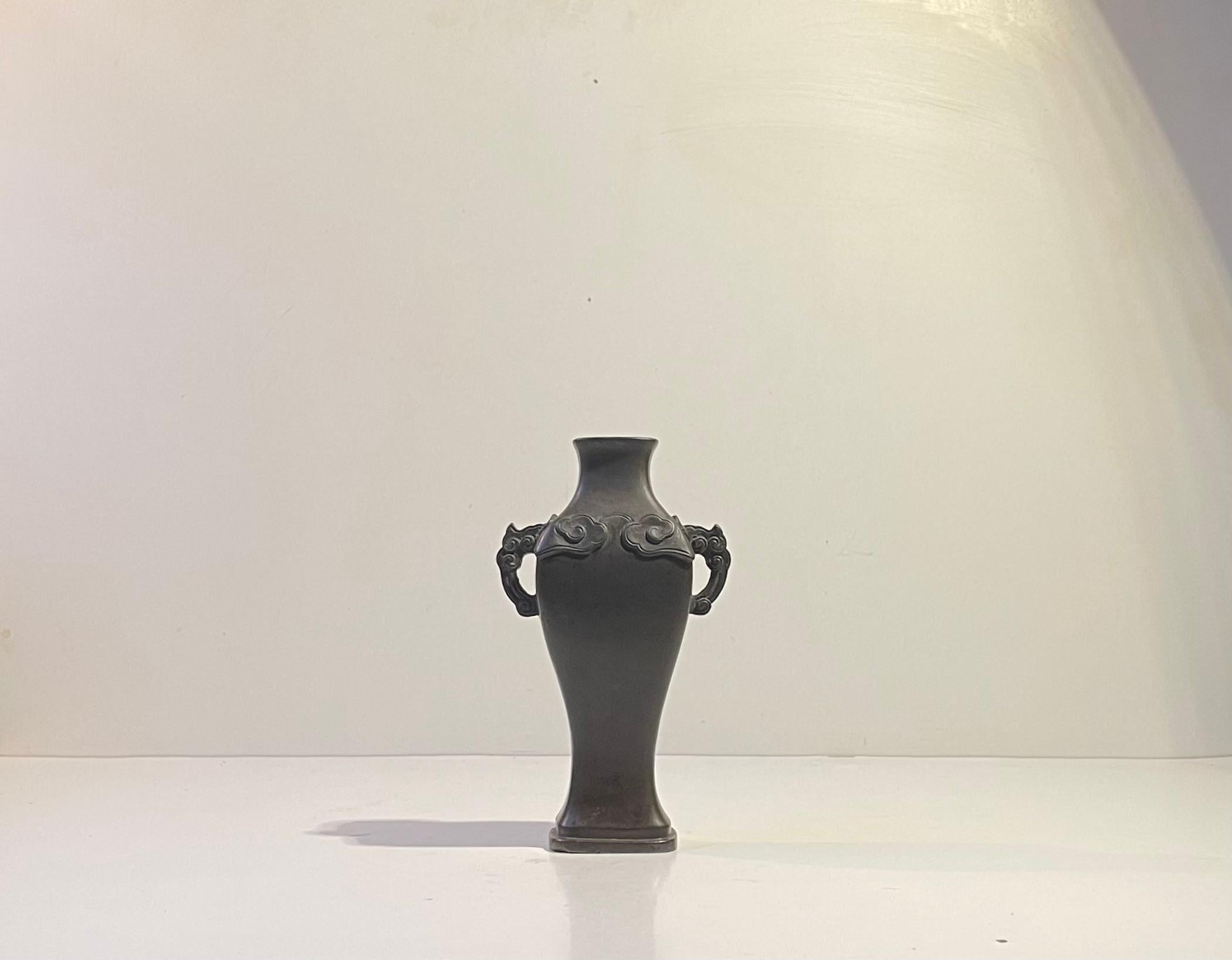 Vase chinois ancien en bronze. Décorées de décors floraux et de poignées en forme de tête d'éléphant stylisée. Base carrée. Style dynastie Ming. Mais il a probablement été fabriqué au milieu et à la fin du XIXe siècle, sous la dynastie Qing.  