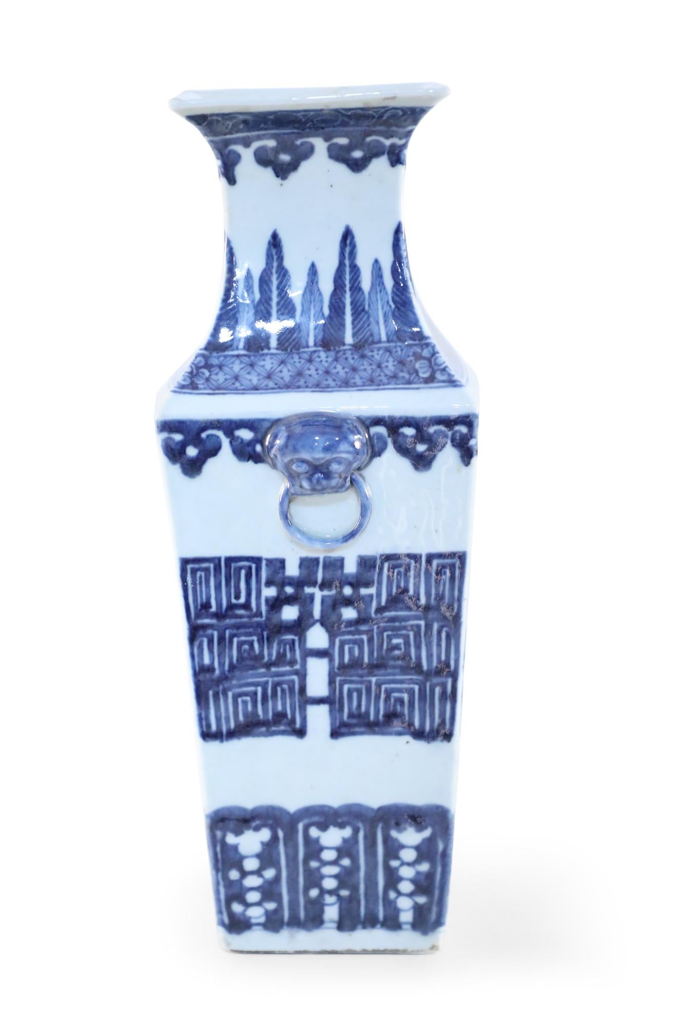 Antique Chinese (19th century) white ceramic vase with a squared form wrapped in dark blue geometric patterns, and adorned with blue foo dog door knockers on two sides.
    