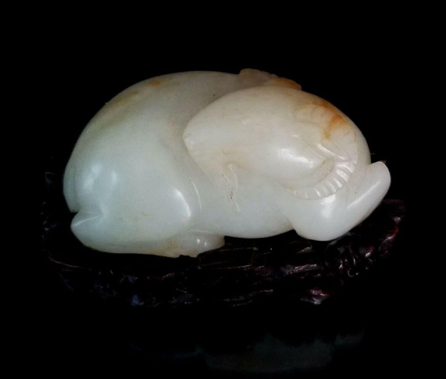 Ancienne effigie de mouton chinoise Hetian en jade blanc sculptée sur un support en bois dur. 
La 