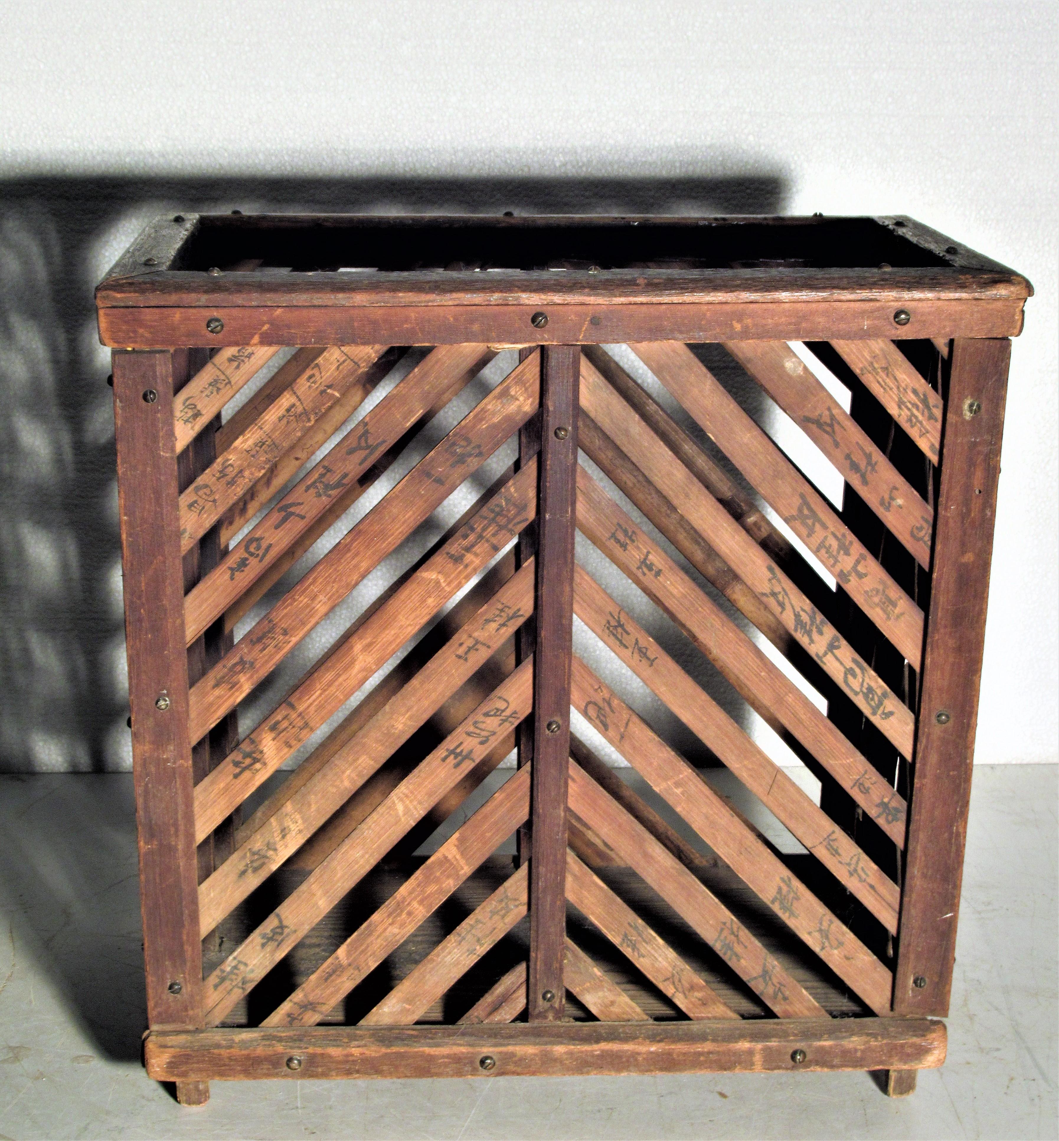 Old Chinese basket constructed of a wood frame with bamboo wood slats having hand written ink writings and small brass screws. Overall beautifully aged patina color with surface wear to wood. 