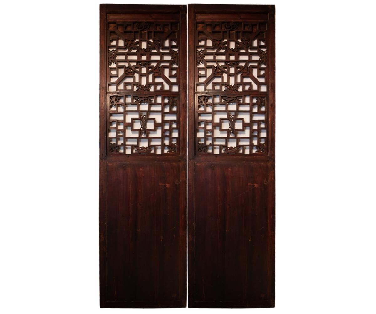 Antique hand carved pair of elm wood screen doors with two carved urns and a flower in the lower panel. The top section is formed by the Chinese longevity pattern on screen with more flowers on the screen. Often these types are seen either at a