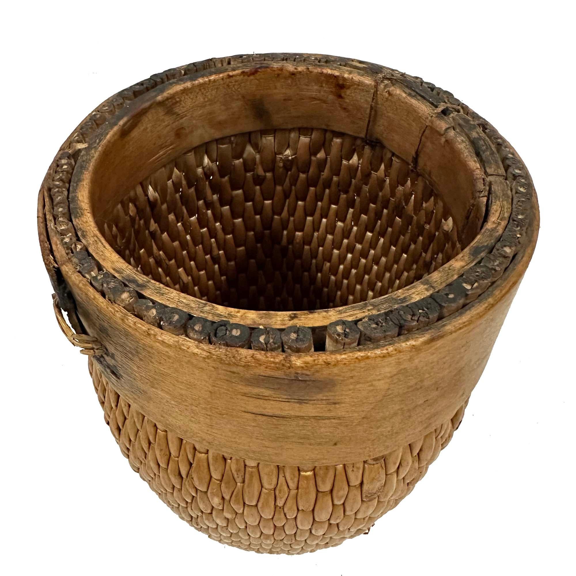 Questo cesto è un cesto da fiume cinese dell'inizio del XX secolo, chiamato anche cesto da grano o da pescatore. Si tratta di un contenitore intrecciato a mano con un bordo in legno curvato. Questo tipo di cesto veniva tradizionalmente utilizzato
