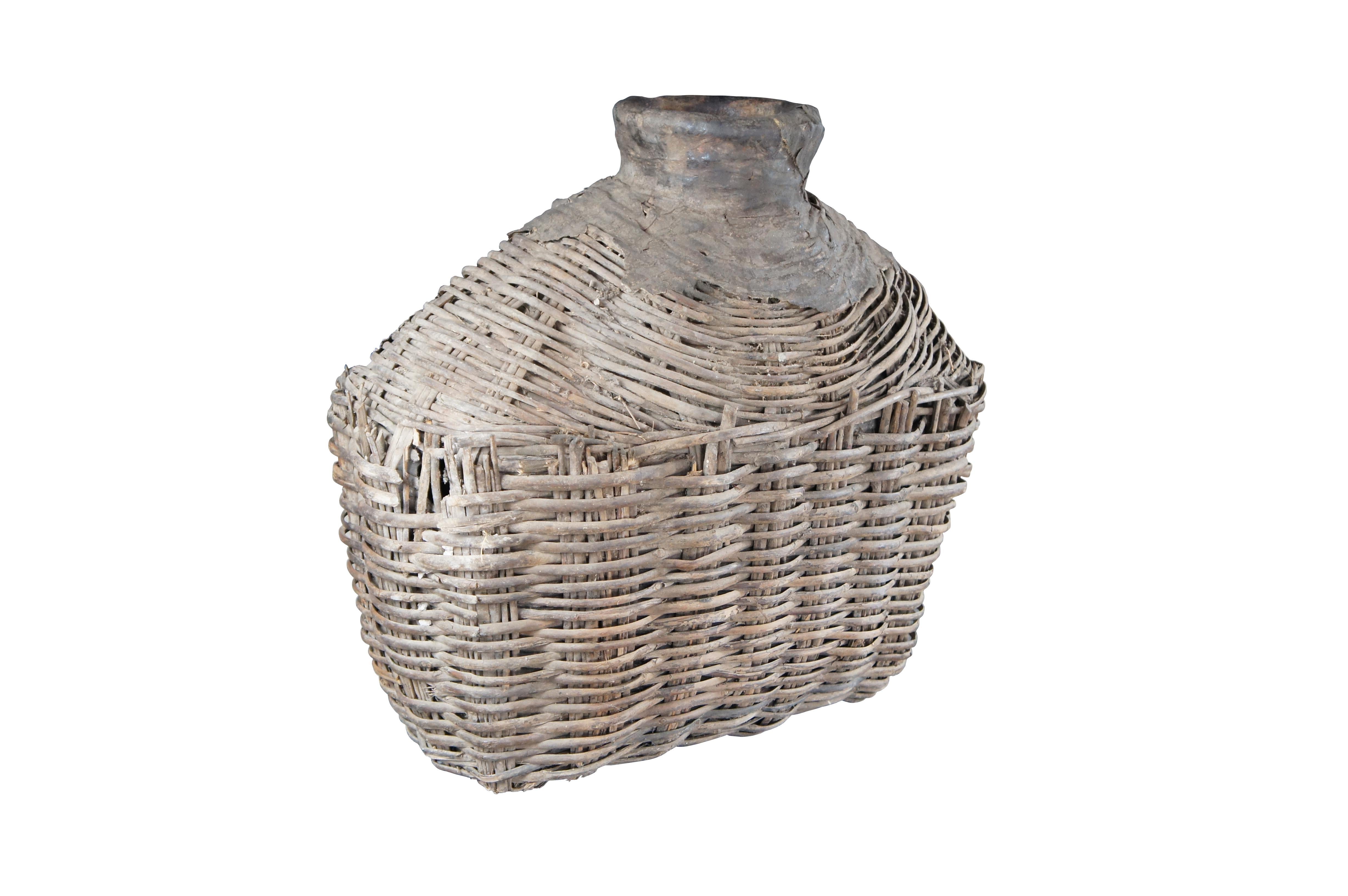 Early 20th Century Chinese Shanxi Willow Oil Container / Food Storage Vessel. Beautifully woven with natural patina from years of use. An unusual yet perfect decorative piece for display in a corner, on a bookcase or in a nook.

Dimensions:
23