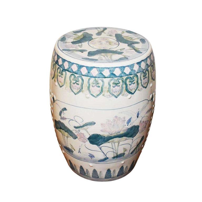 A fabulous chinoiserie ceramic garden stool. Great for use as a stool for extra seating, a small side table, or as a plant stand. This lovely stool is created from ceramic and features a glazed floral motif in pink, green, blue, and white. Raised