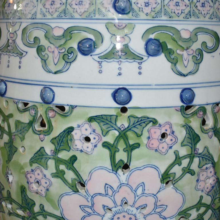 A fabulous chinoiserie ceramic garden stool. Great for use as a stool for extra seating, a small side table, or as a plant stand. This lovely stool is created from ceramic and features a glazed floral motif in pink, green, blue, and white. Raised