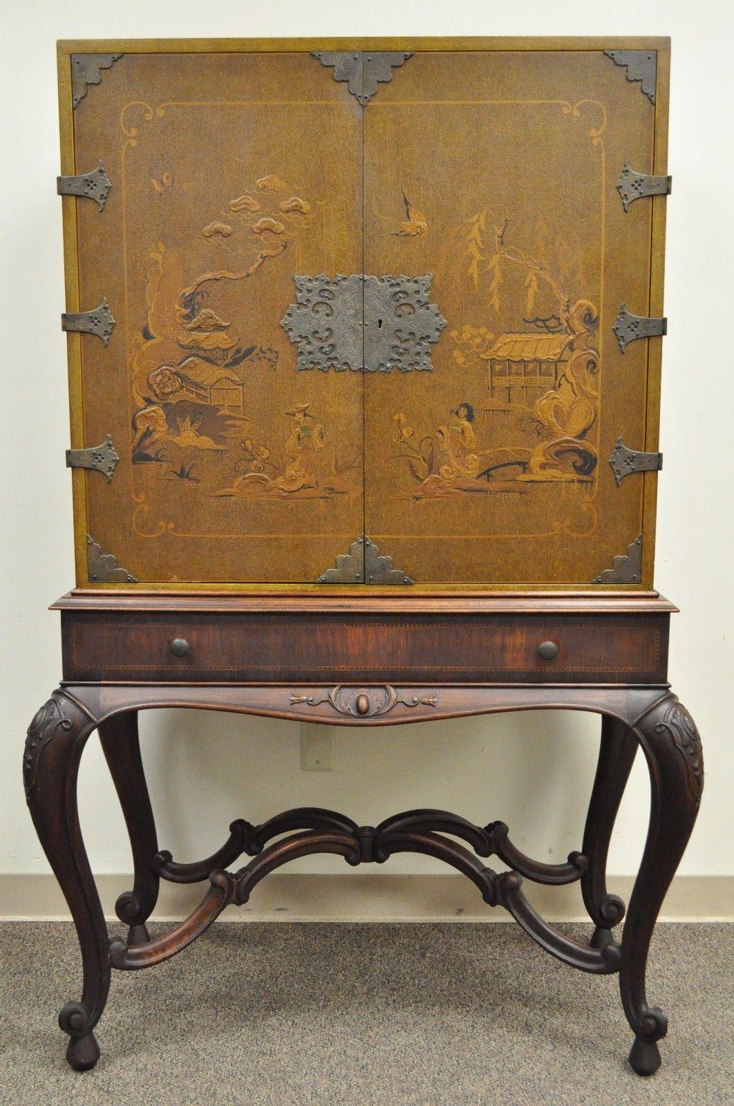 Early 20th century chinoiserie / George III style cabinet. Item features beautiful hand gilt painted cabinet doors and sides depicting Asian scenes, finely etched ornate hardware, carved solid walnut stretcher base and cabriole legs, single dovetail