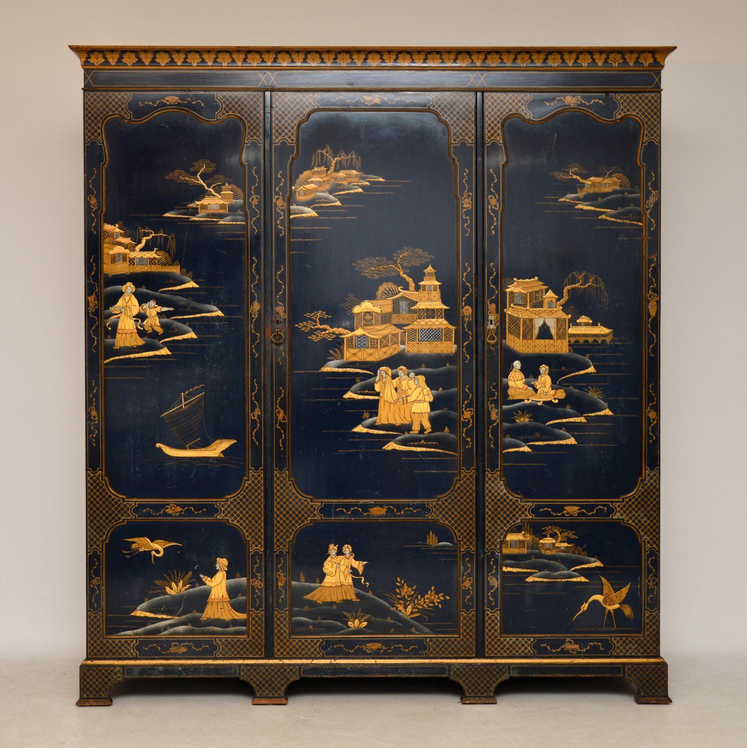 Antique three-door wardrobe covered in chinoiserie decoration dating from the 1910 period & made by the famous English cabinet maker Hille. It’s stunning quality inside & out, with a well fitted interior consisting of drawers, slides, shelves & a