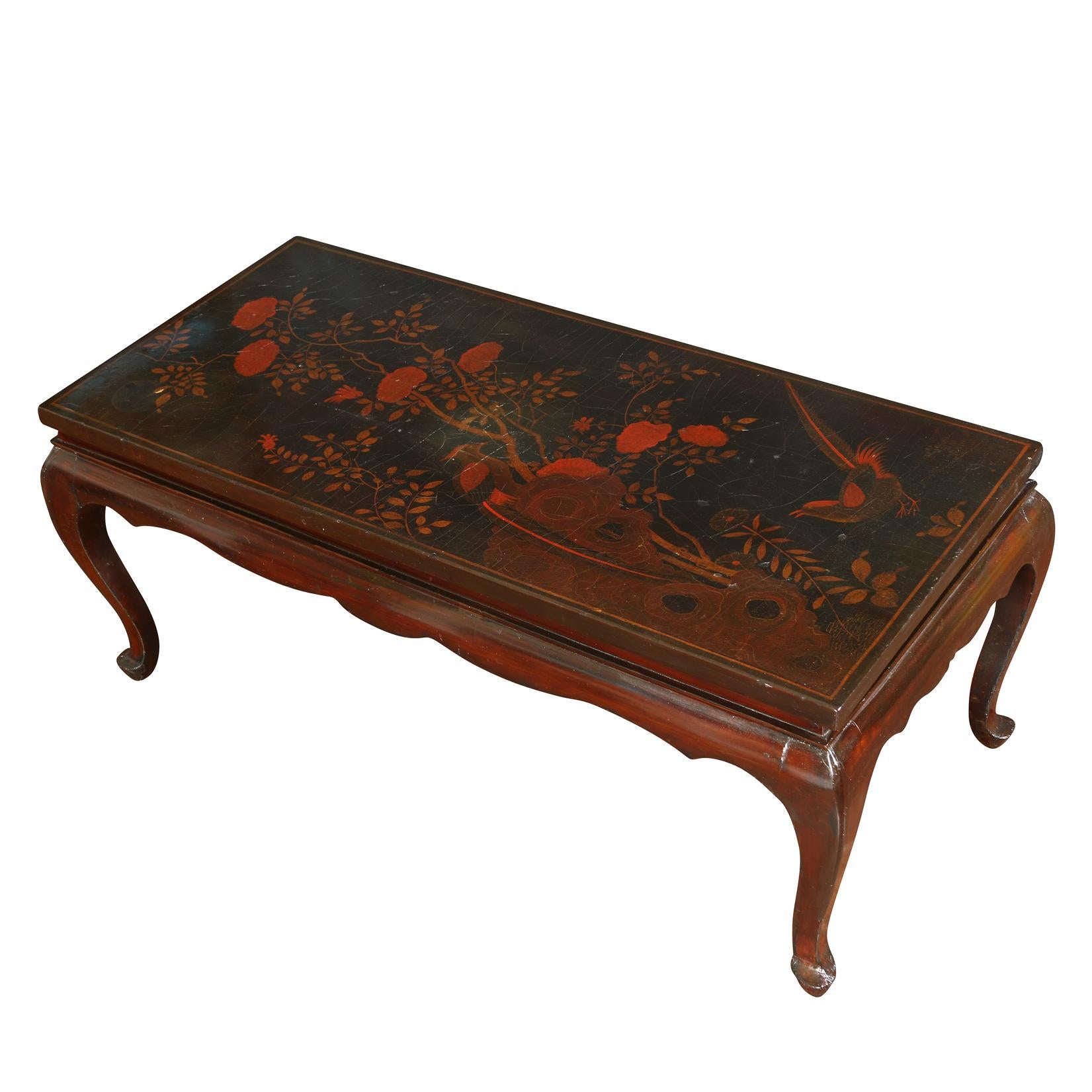 Antique chinoiserie lacquered, low coffee table with red flower detail and cabriole legs.