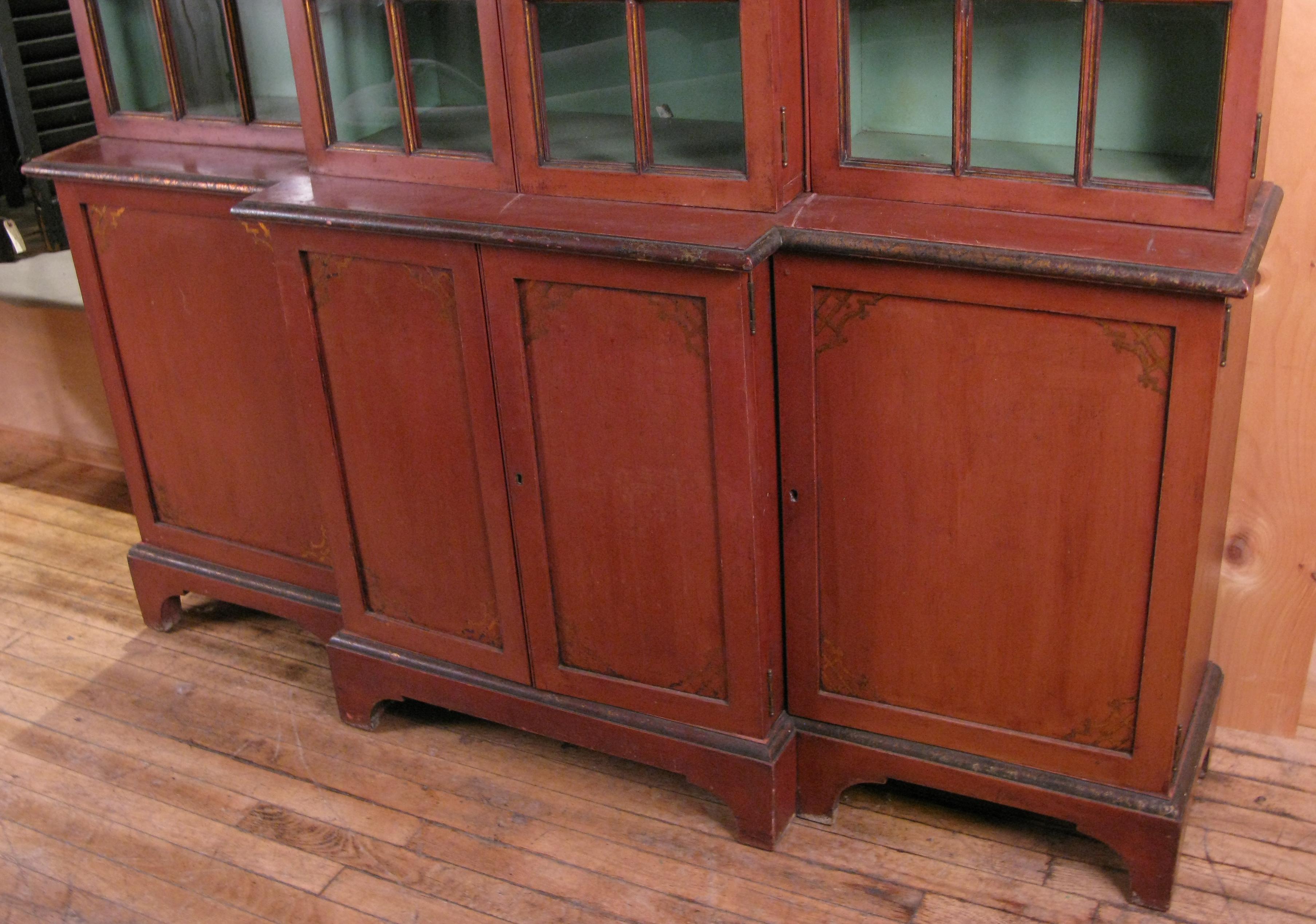 A very beautiful antique 1920s bookcase in chinoiserie style. Finished in Pompeii red, with interiors in Paris green. The lower case has four doors concealing shelves, and the upper portion has four divided pane glass doors also concealing shelves.