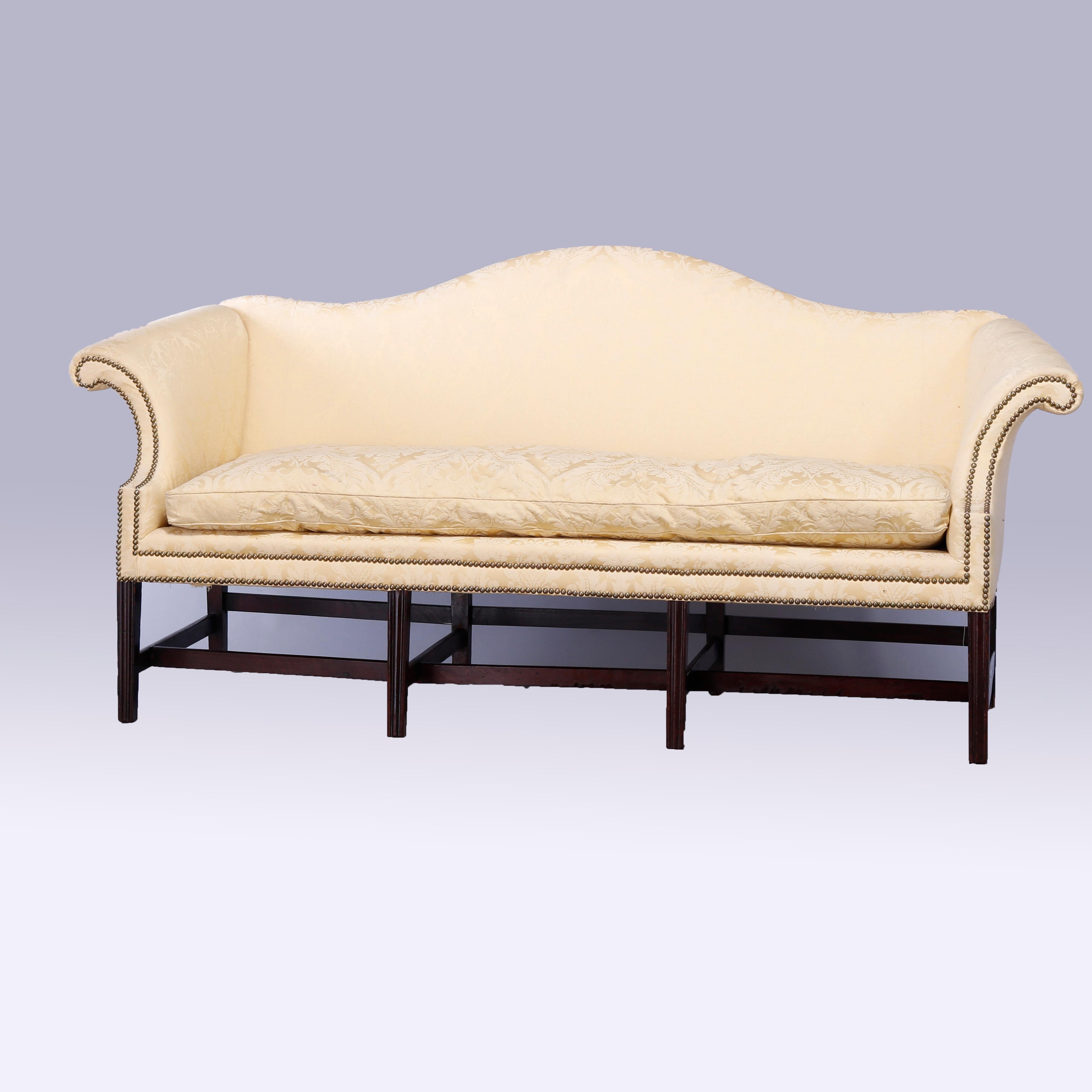 An antique Chippendale sofa offers upholstered camel back form with scroll arms and down cushion on walnut frame having eight square and straight legs, c1810

Measures - 38.75'' H x 81.5'' W x 31'' D; seat height 16