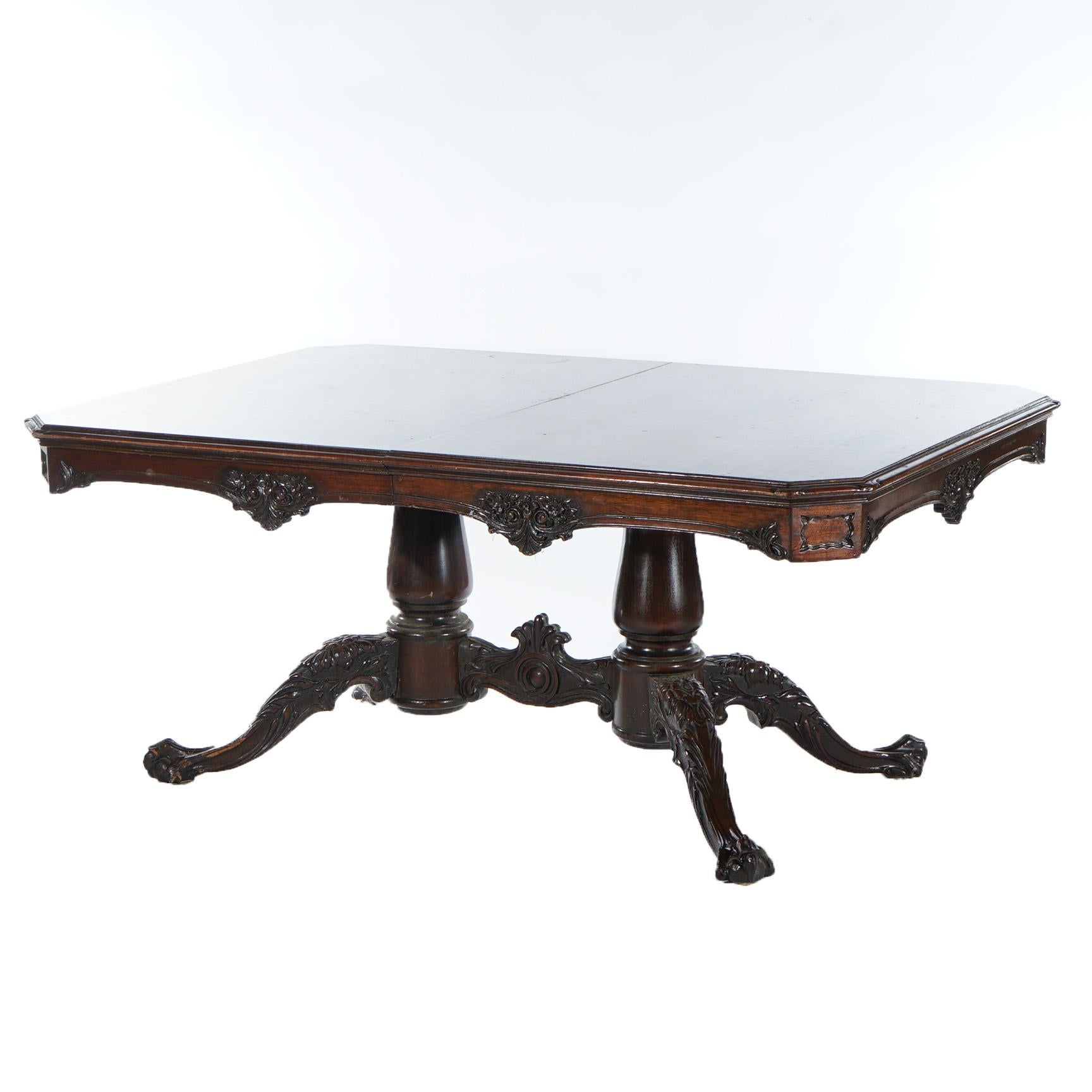 An antique Chippendale style dining table offers mahogany construction with carved and shaped skirt, raised on double pedestal base, each have tripod cabriole legs terminating in claw and ball feet, c1930

Measures - 30