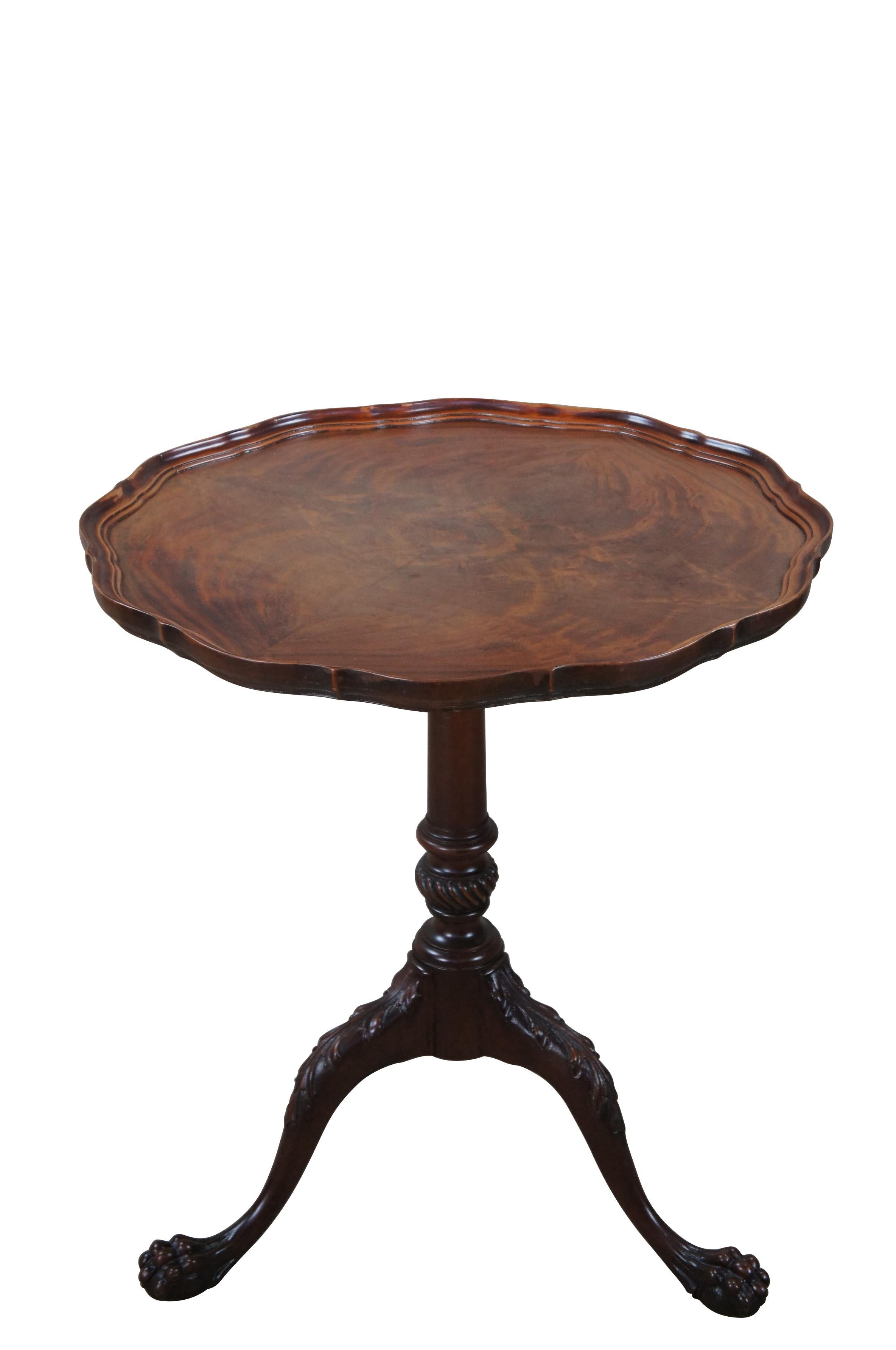 Antique turn of the century pie crust tea table.  Made of mahogany featuring scalloped gallery top supported by tri foot pedestal base with ornate ball claw feet and acanthus accents.

Dimensions:
26