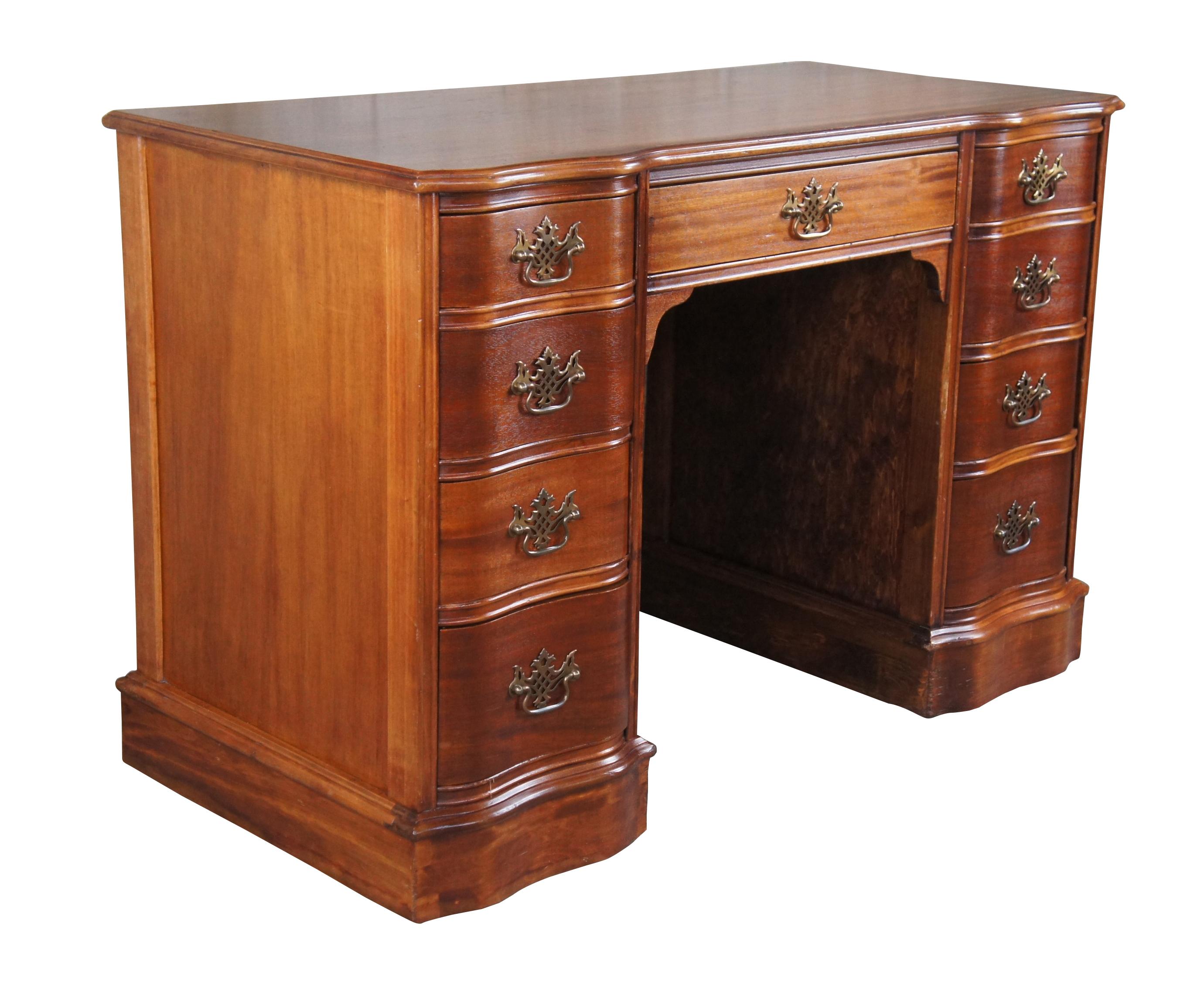 Antique Chippendale library writing desk.  Made of mahogany featuring serpentine rectangular form with nine dovetailed drawers and pierced brass hardware.

Dimensions:
43.5