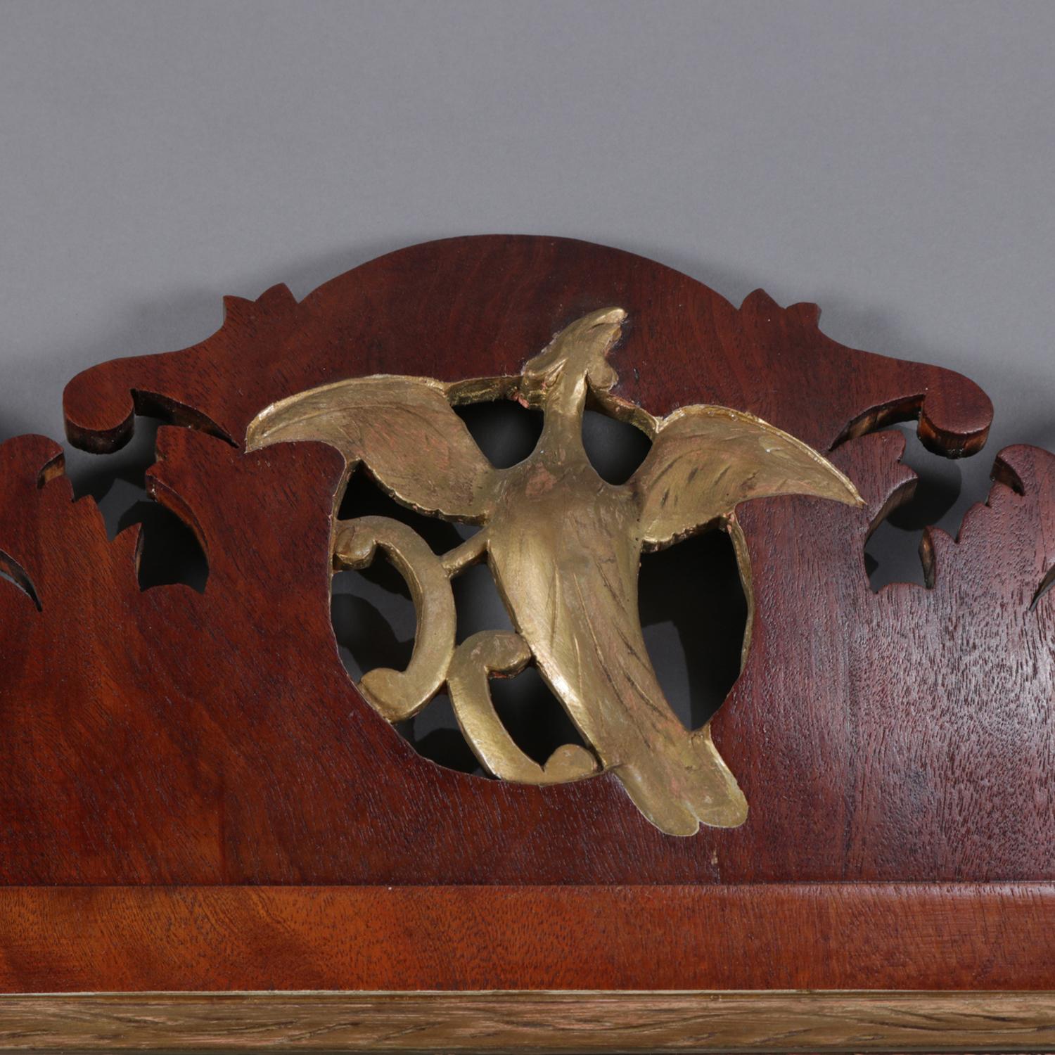 Lo specchio da parete Chippendale ha una cornice sagomata in mogano a forma di voluta con stemma di fenice dorato e bordi dorati, circa 1820.

Misure: 38